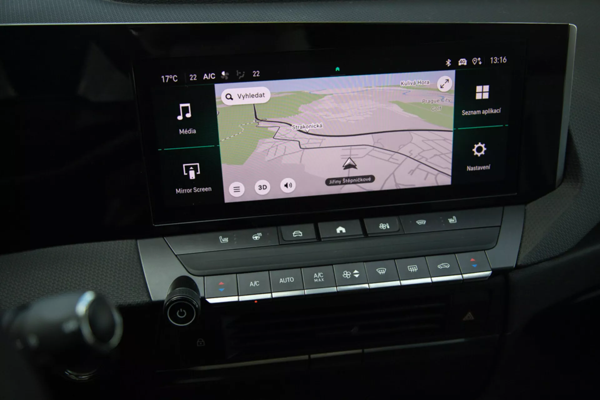 Zbliżenie na system infotainment i kontroli klimatyzacji w konsoli środkowej Opel Astra 2022, pokazujące nawigację GPS na wyświetlaczu, łączność Bluetooth oraz ustawienia temperatury