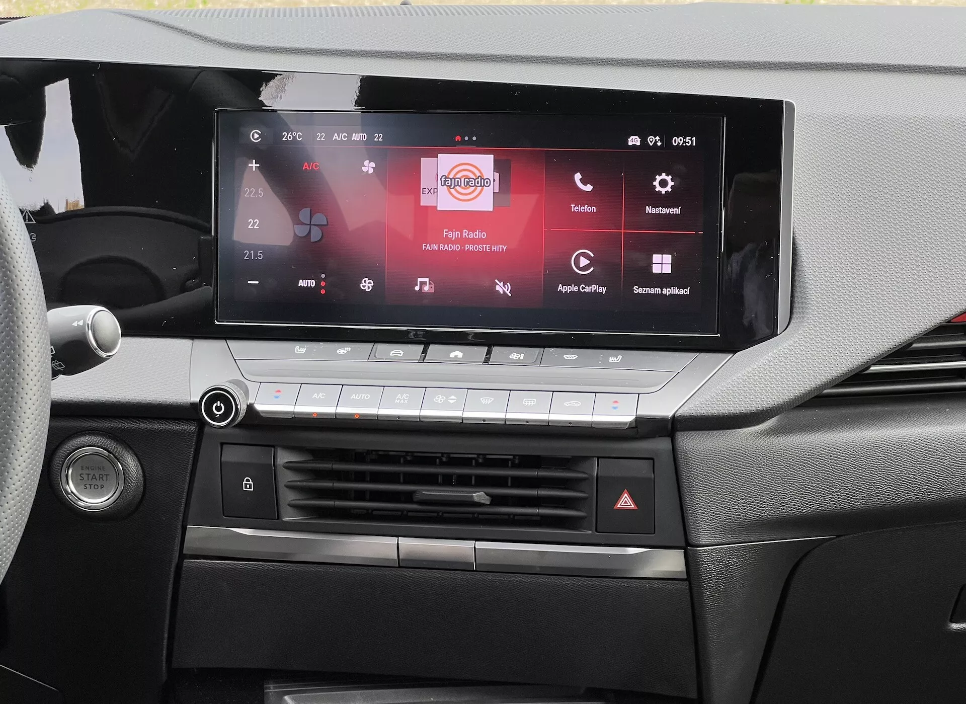 Widok deski rozdzielczej Opel Astra 2022 podkreślający ekran dotykowy systemu informacyjno-rozrywkowego zgodnego z Apple CarPlay i Android Auto, system kontroli klimatu i szczegółowy projekt kabiny