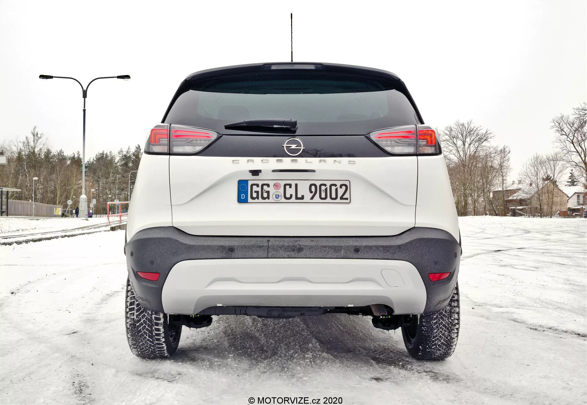 Widok z boku Opel Crossland 1.2 2021 w imponującym otoczeniu miejskim, prezentujący jego elegancki design i nowoczesne funkcje