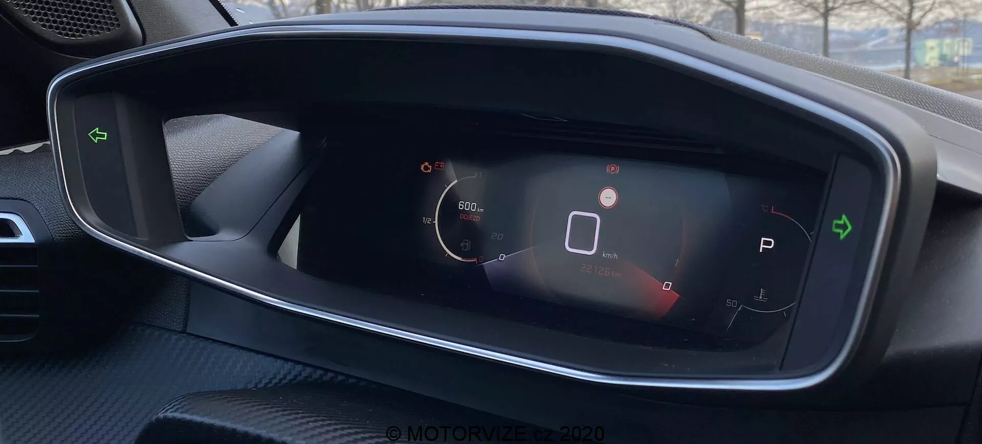 Zbliżony widok cyfrowego zestawu wskaźników Peugeot 2008 2020, zawierający prędkościomierz, ikonę stanu pojazdu, wybór biegu w trybie parkowania, symbol baterii i dodatkowe wskaźniki stanu. Czysty, wysoko kontrastowy design z perspektywy kierowcy.