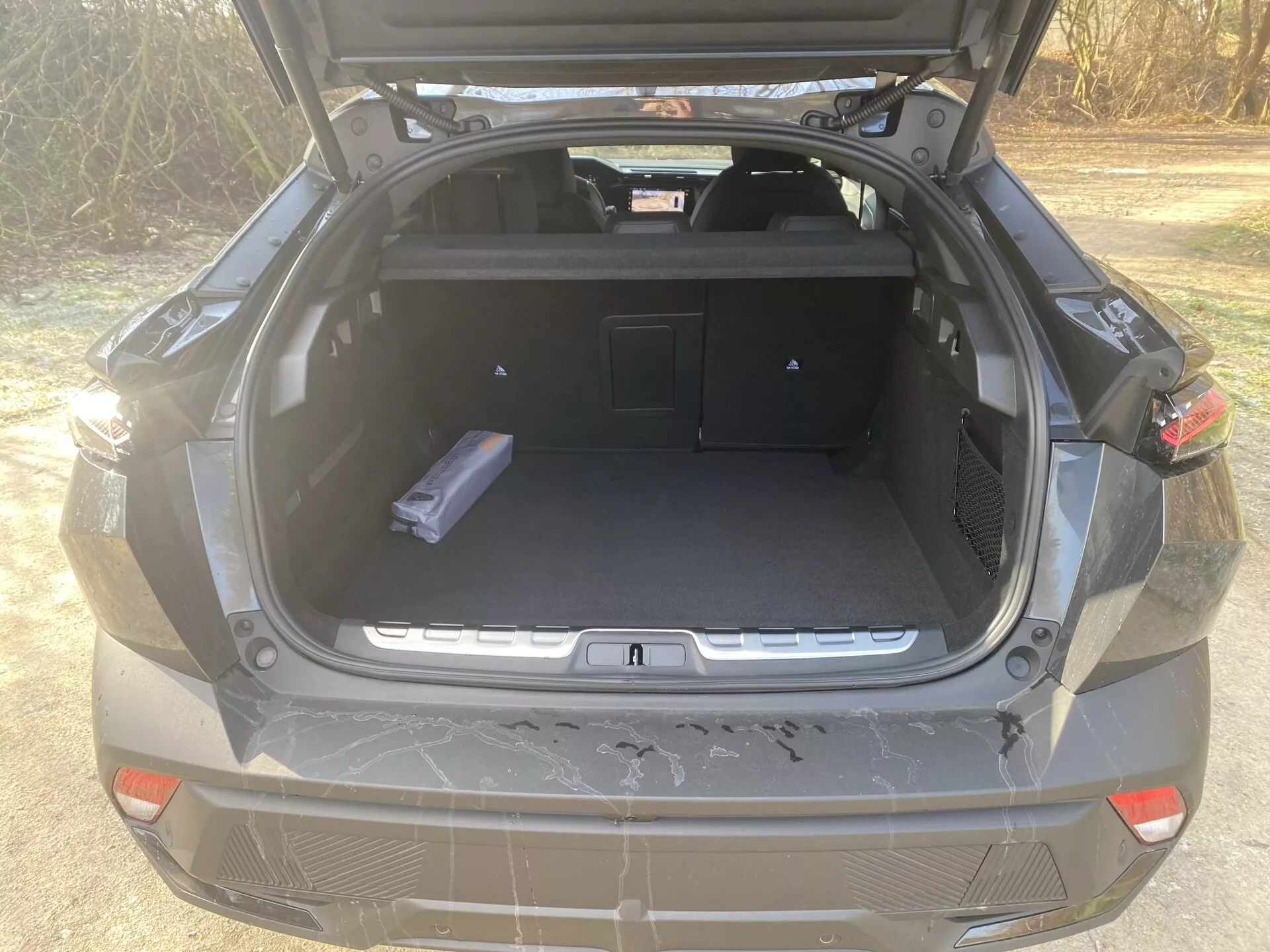 Peugeot 408 z 2023 roku, 1. generacja, z eleganckim, aerodynamicznym kształtem, innowacyjnymi reflektorami LED i nowoczesnym wnętrzem.
