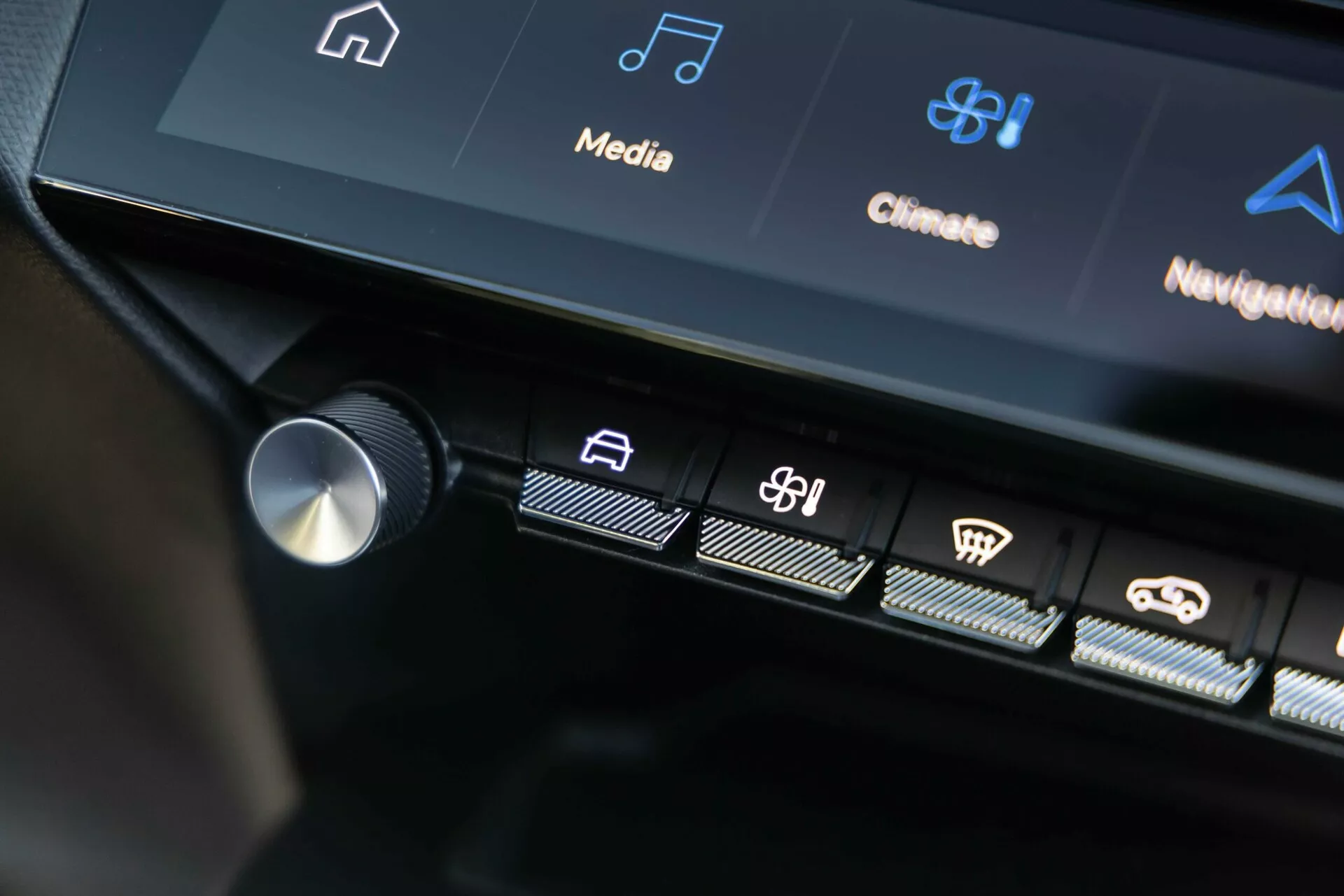 Centralny interfejs sterujący Peugeota 408 z 2023 roku pokazujący podświetlone przyciski dotykowe i część wyświetlacza dotykowego z ikonami systemu infotainment i kontroli klimatyzacji, prezentujący zaawansowaną technologię pojazdu