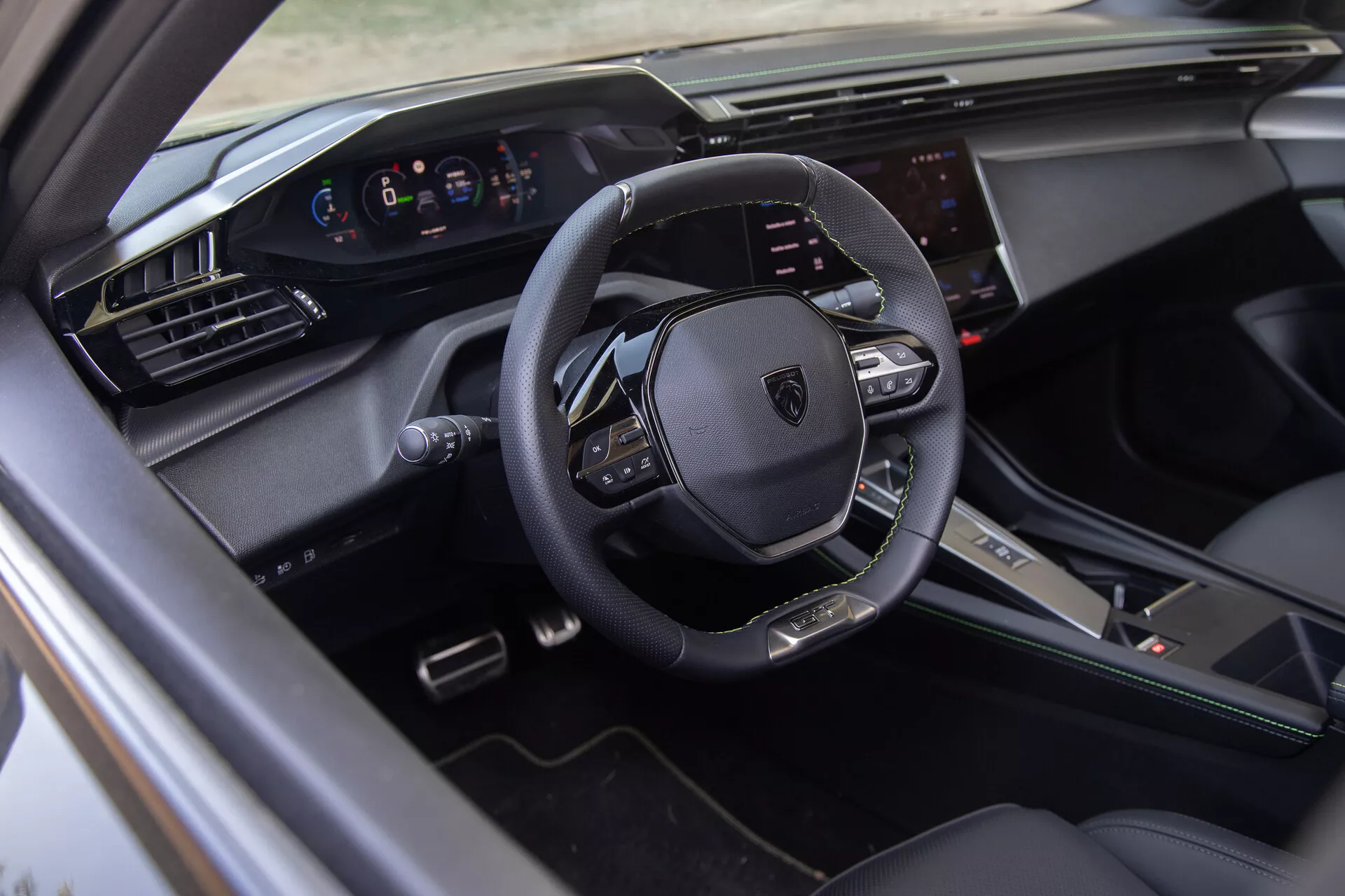 Wnętrze Peugeot 408 2023 pokazujące wielofunkcyjną kierownicę obszytą skórą, cyfrowy zestaw wskaźników i ekranowy system informacyjno-rozrywkowy z punktu widzenia strony kierowcy