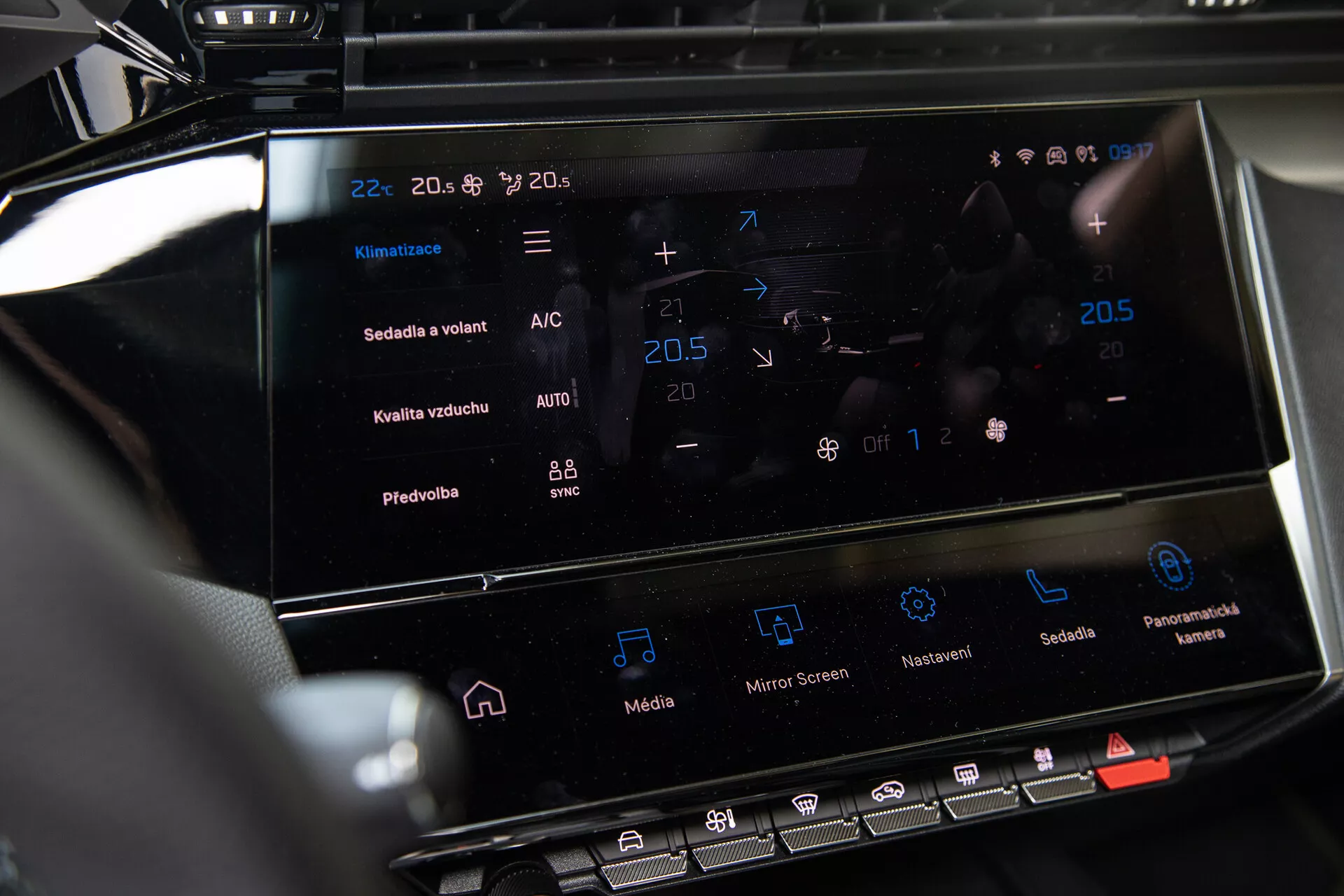 Centralna konsola Peugeot 408 2023 pokazująca dotykowy system informacyjno-rozrywkowy i interfejs kontroli klimatyzacji z ustawieniami temperatury i zaawansowanymi funkcjami