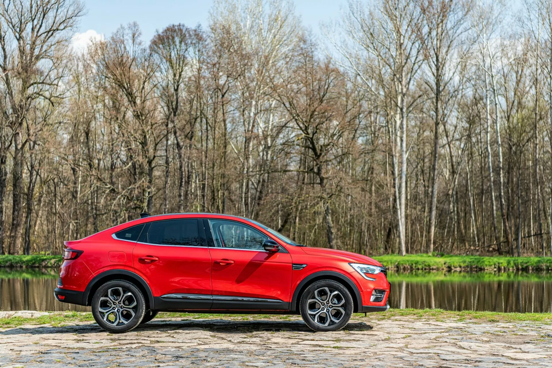 Widok z przodu Renault Arkana 2021 w stylowym, nowoczesnym wzornictwie z eleganckimi reflektorami LED i odważnym, dynamicznym grillem, ukazującym jej sportowy, a jednocześnie wyrafinowany wygląd.
