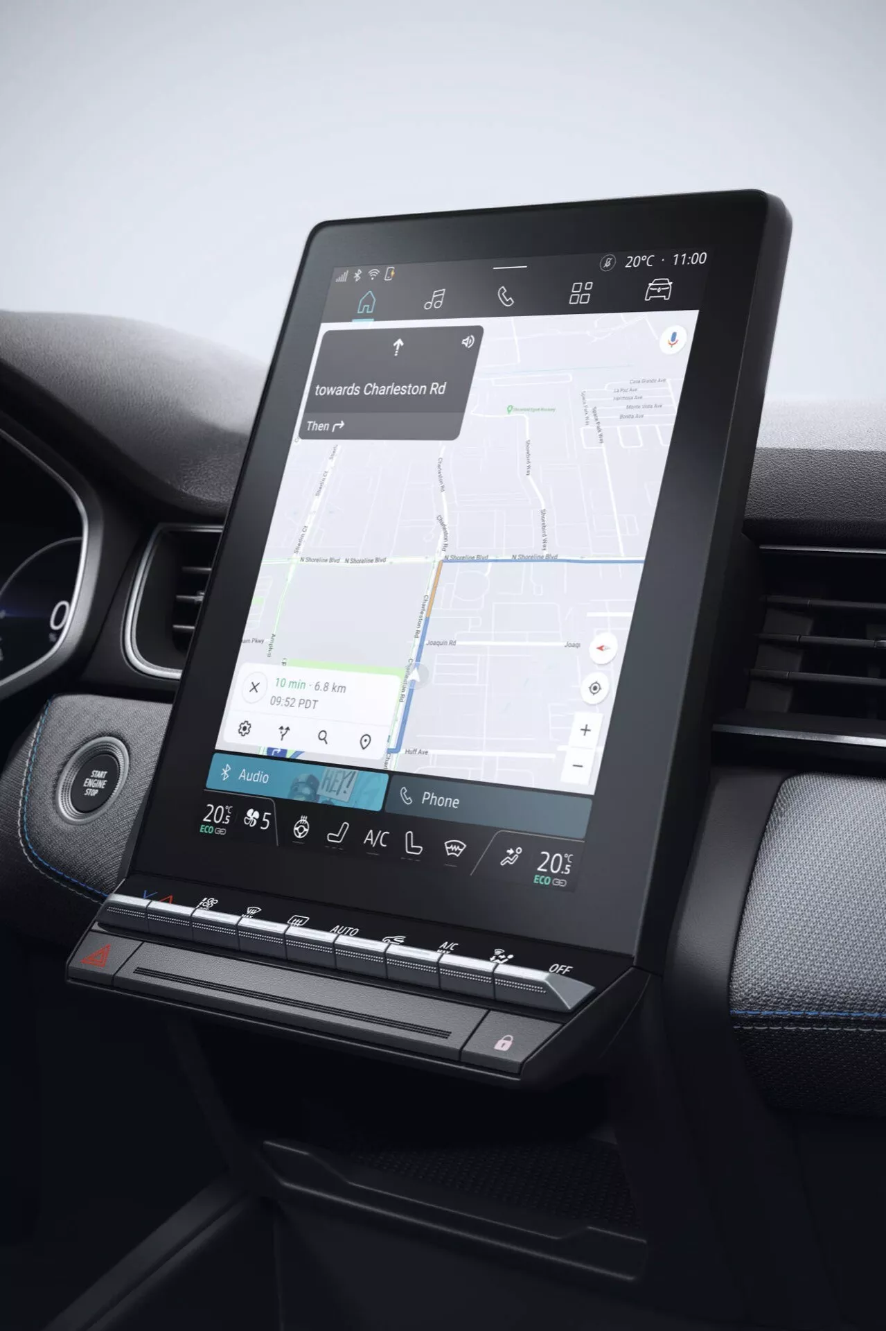 Zbliżenie na system infotainment Renault Captur 2024 (II lifting), pokazujący pionowy ekran dotykowy z mapą nawigacyjną, połączony z fizycznymi przyciskami i pokrętłami do klimatyzacji i głośności, otoczony materiałem wysokiej jakości z widocznymi szwami