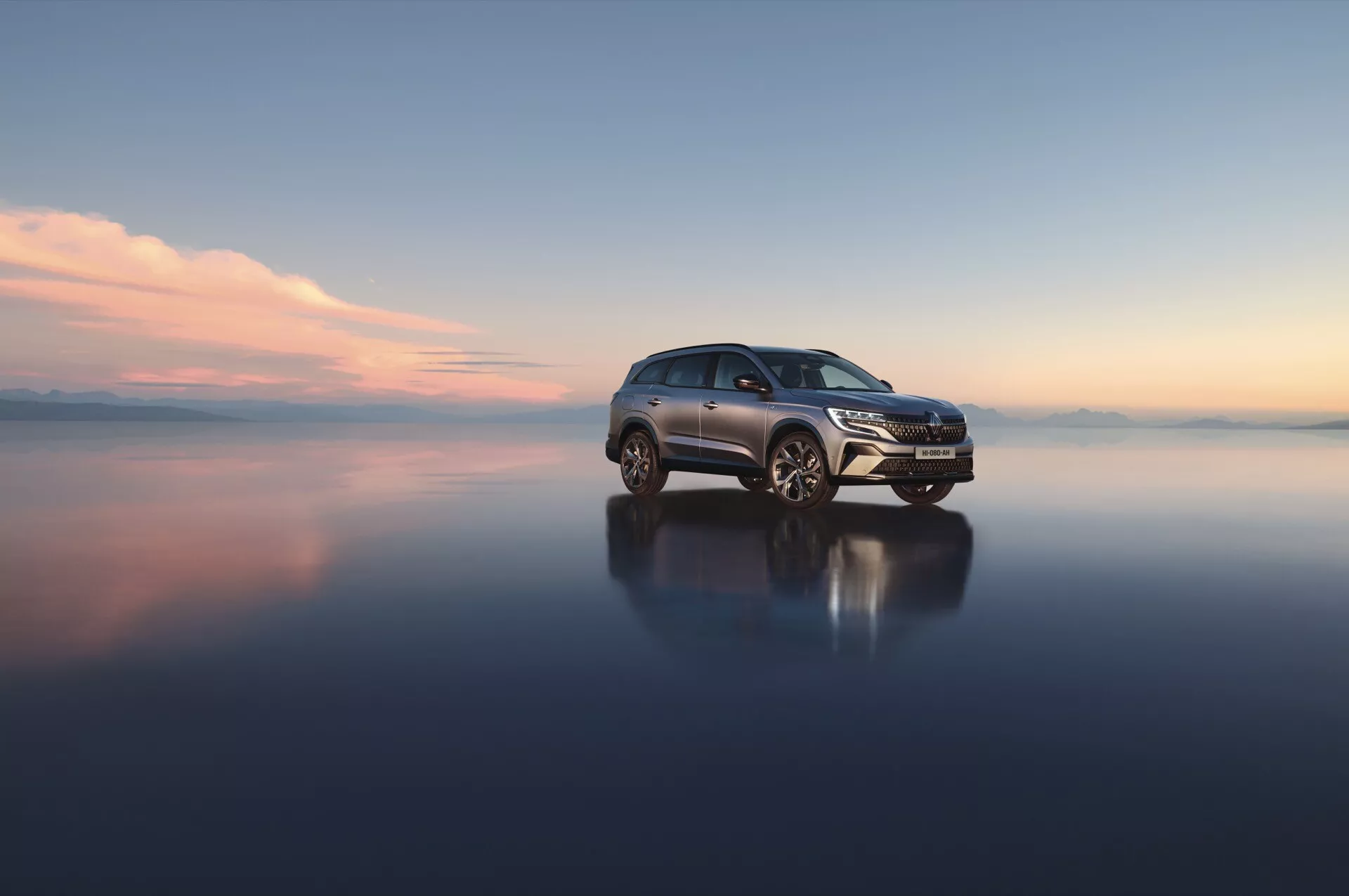 Renault Espace VI 2023 na odbijającej powierzchni eksponujący grill przedni, reflektory LED i koła ze stopu z widoku trzy czwarte z przodu, podkreślając aerodynamiczny design i zaawansowane funkcje technologiczne