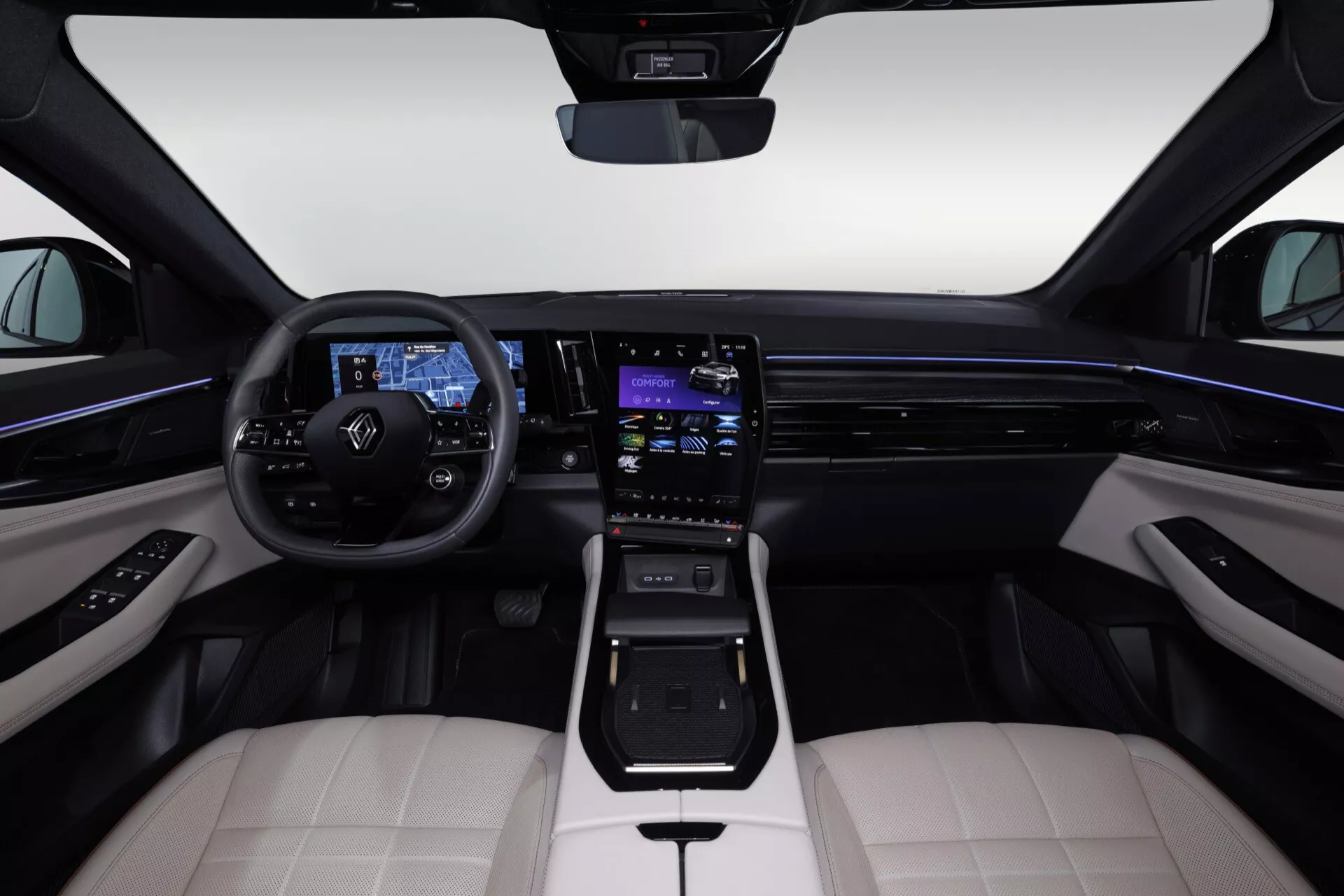 Widok wnętrza Renault Espace VI 2023 z tylnej środkowej kanapy ukazujący Kierownicę z Przyciskami, Cyfrowy Panel Instrumentów, System Infotainment Dotykowy, Oświetlenie Ambiente, Dwu-tonowe Skórzane Siedzenia, Nowoczesny Selekktor Przekładni, Materiały Wysokiej Jakości i Eleganckie Elementy Wzornictwa