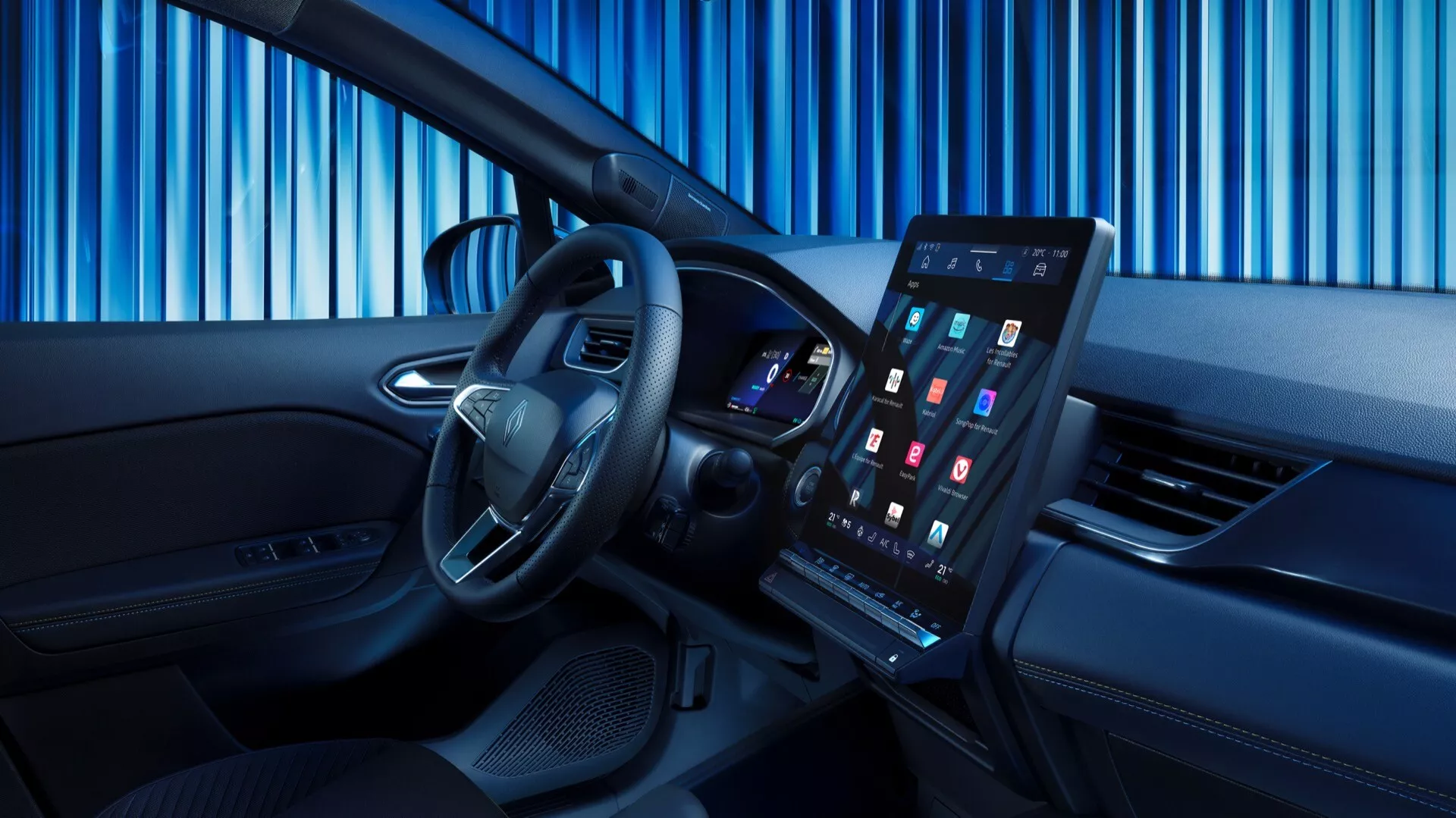 Obraz przedstawia wnętrze Renault Symbioz 2024 (1. generacja) z nowoczesnym i wyszukanym designem. Zdjęcie wykonano z lekko przesuniętego kąta w kierunku przedniego siedzenia pasażera, co daje wyraźny widok na obszar kierowcy. Na pierwszym planie wyraźnie widoczna jest kierownica ze srebrnymi akcentami i zamontowanymi przyciskami sterującymi. Za kierownicą widać cyfrową tablicę rozdzielczą z kolorowym wyświetlaczem. Centralna część deski rozdzielczej zawiera duży, pionowo zorientowany dotykowy system infotainment. Wnętrze ma dwukolorowy wygląd z wysokiej jakości materiałami, cienkim otworem wentylacyjnym pod ekranem oraz panelami sterującymi na drzwiach kierowcy.