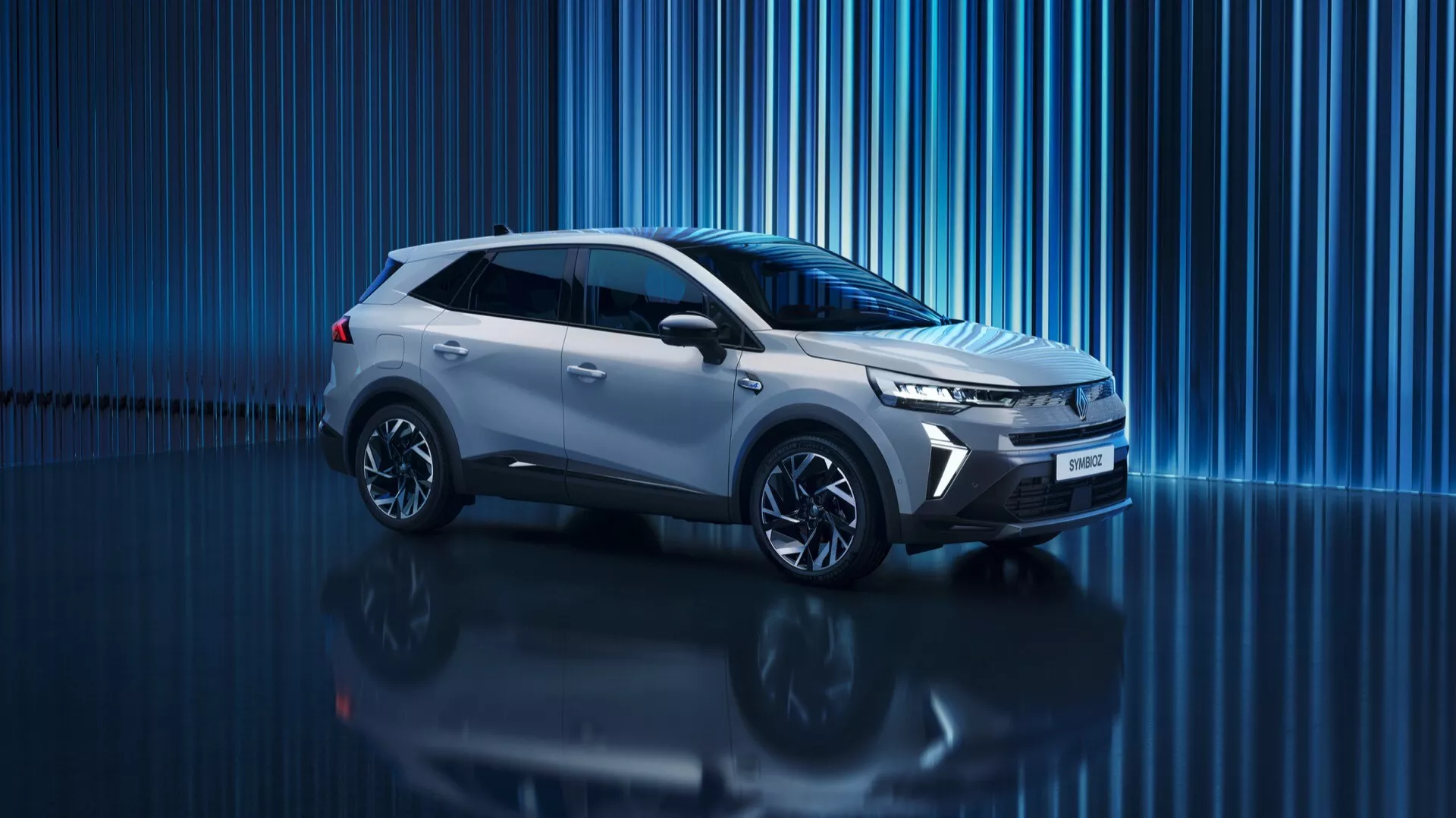 Cyfrowy obraz studyjny Renault Symbioz 2024 1 generacji, nowoczesnego SUV-a o eleganckim i dynamicznym designie. Widok z profilu pod lekkim kątem od przodu, pokazujący boczny profil, przednią część, kratkę, reflektory, koła i lusterka boczne. Centralna pozycja w kadrze, fotografia z niskiego kąta podkreślająca potężną posturę samochodu. Ostro zakończone, kanciaste reflektory sugerujące technologię LED i światła do jazdy dziennej. Wąska, pozioma kratka podkreślająca aerodynamikę. Rzeźbiona linia charakterystyczna biegnąca od przedniego błotnika do tyłu, nadająca aerodynamiczny wygląd. Wieloramienne felgi aluminiowe wzmacniają sportowy wygląd. Refleksyjna powierzchnia pod samochodem i niebieskie abstrakcyjne tło cyfrowe tworzą estetykę premium i futurystyczną, potencjalnie wskazującą na nowoczesną lub nawet elektryczną technologię napędową.