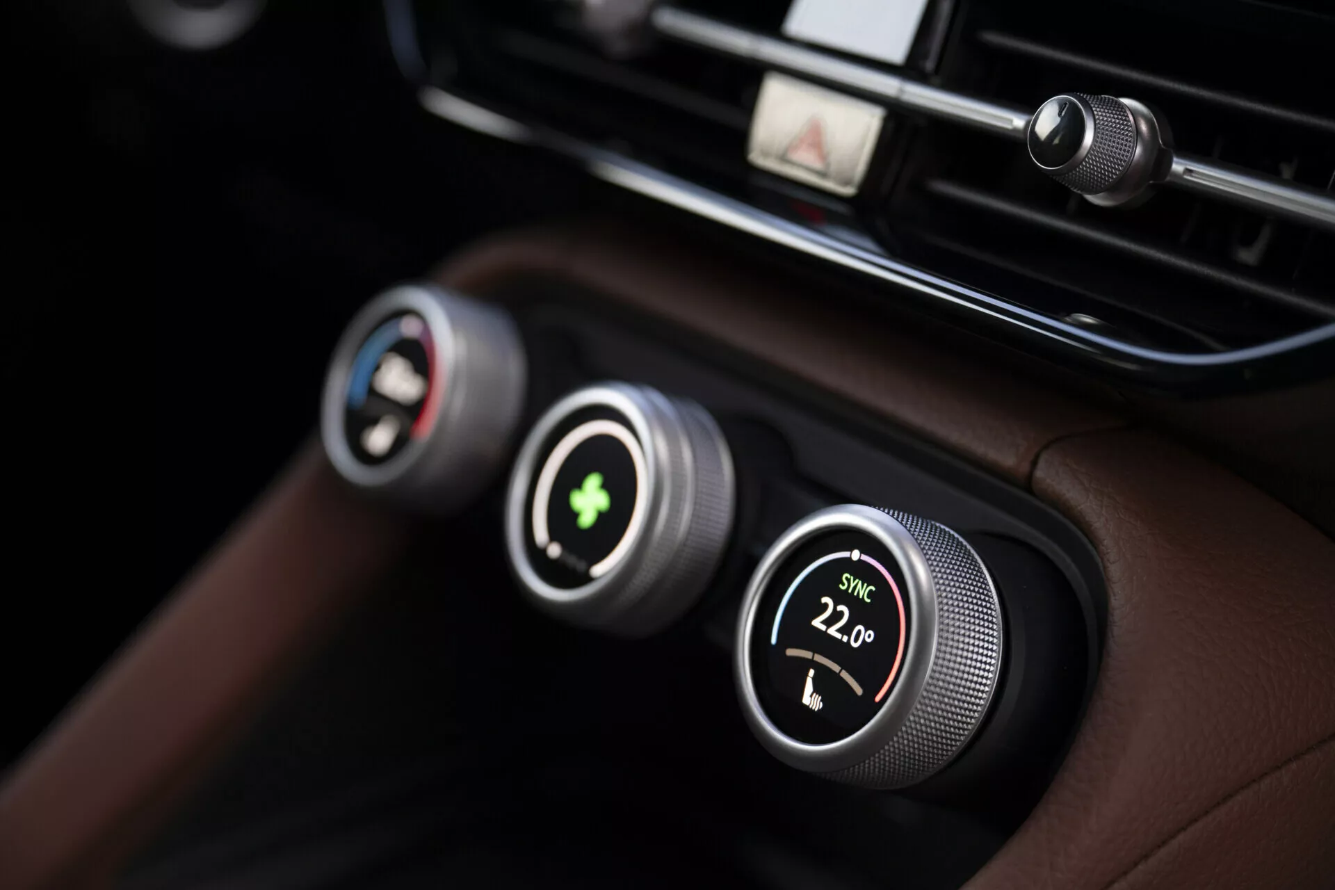 Zbliżenie na system kontroli klimatu Skoda Kodiaq 2024 z dwustrefową regulacją temperatury z metalowymi pokrętłami i wyświetlaczami cyfrowymi, na luksusowej czarnej skórzanej desce rozdzielczej