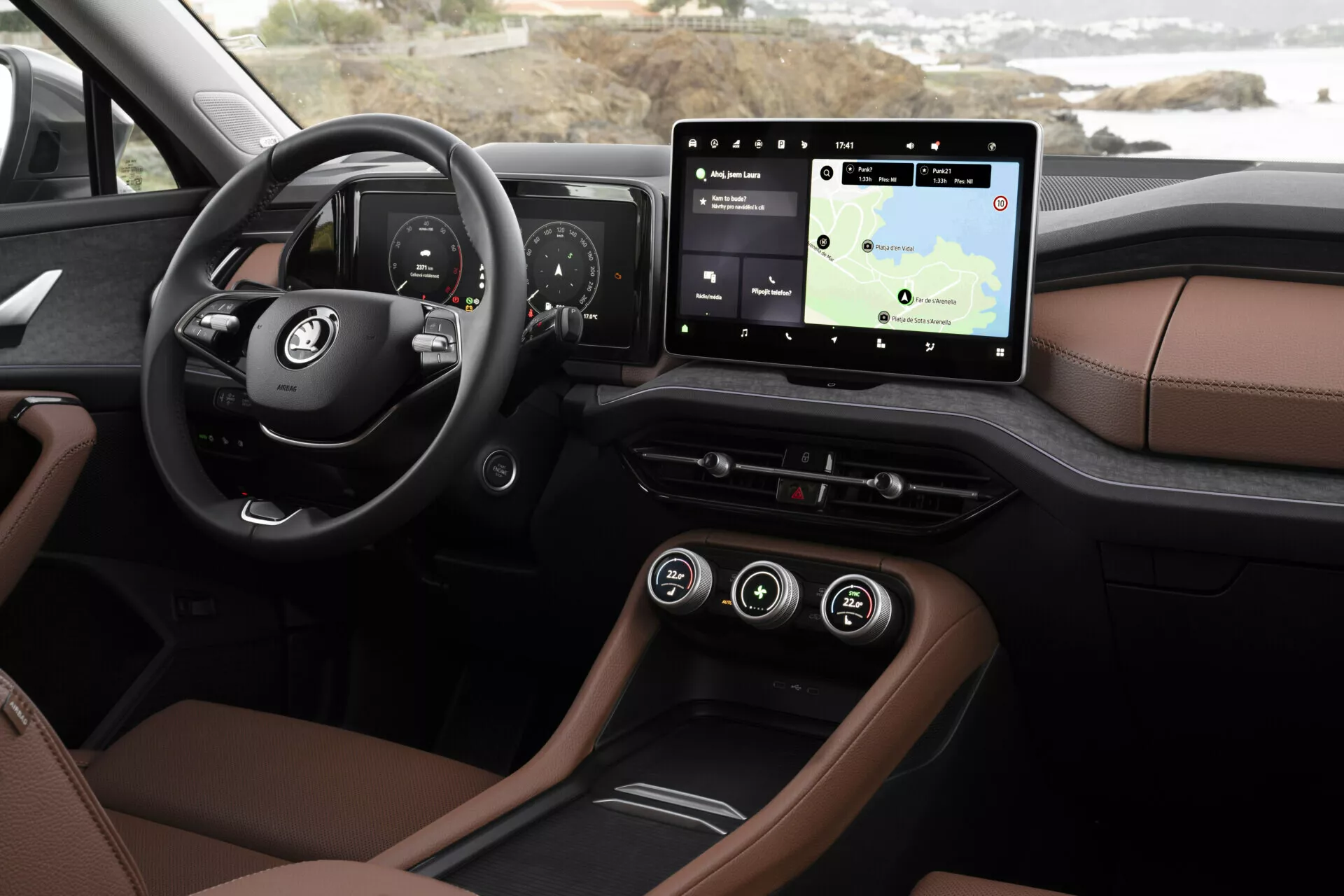 Zbliżenie wnętrza Skoda Kodiaq 2024 ukazujące desce rozdzielczej i funkcje technologiczne z perspektywy kierowcy, w tym cyfrowy zestaw wskaźników, system infotainment z ekranem dotykowym i nawigacją, luksusową tapicerkę w dwóch tonacjach, oświetlenie ambientowe i nowoczesne opcje łączności