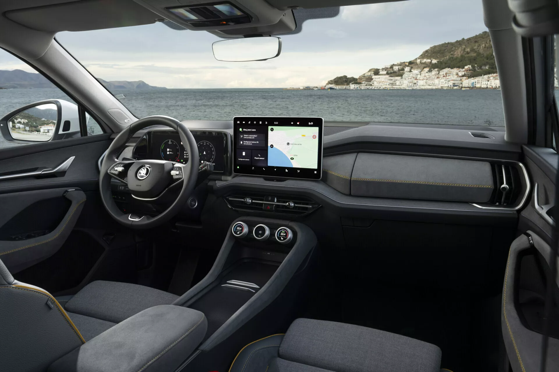Wnętrze Skoda Kodiaq 2024 pokazujące stronę kierowcy z widokiem na kierownicę, deskę rozdzielczą i konsolę środkową podkreślającą nowoczesny design i technologię