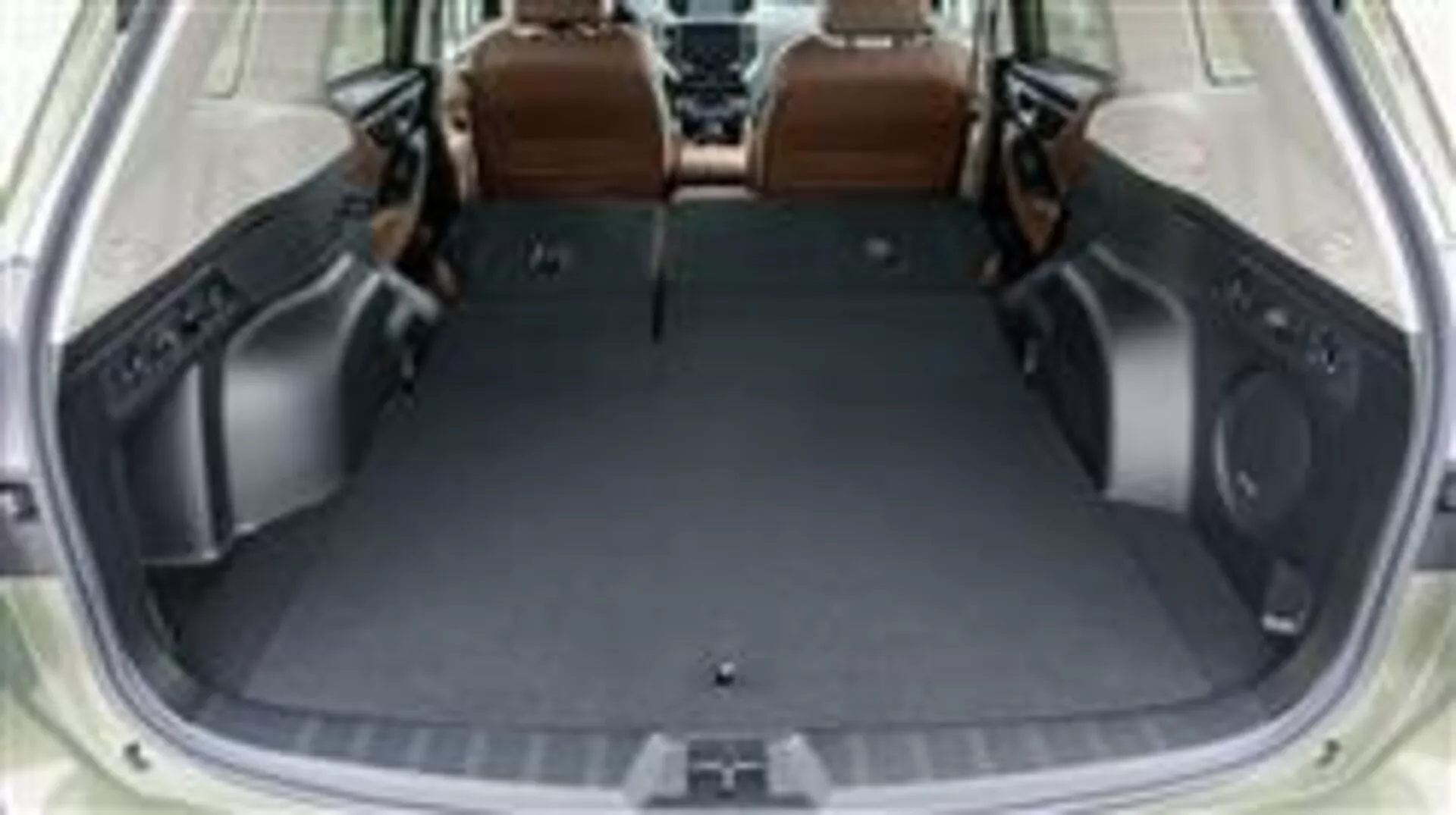 Przestrzeń bagażowa Subaru Forester 2015 z złożonymi tylnymi siedzeniami, prezentująca pustą przestrzeń ładunkową i luksusowe wnętrze z brązowej skóry, widziana z podniesionej perspektywy