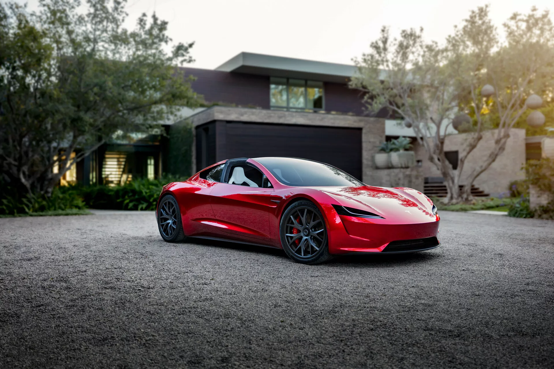 Tesla Roadster 2020 (2. generacja) w oszałamiającym czerwonym kolorze. Prezentuje elegancki aerodynamiczny design z zaawansowanymi funkcjami, w tym wysokowydajnym silnikiem elektrycznym, prędkością maksymalną ponad 250 mph i przyspieszeniem od 0 do 60 w zaledwie 1,9 sekundy.
