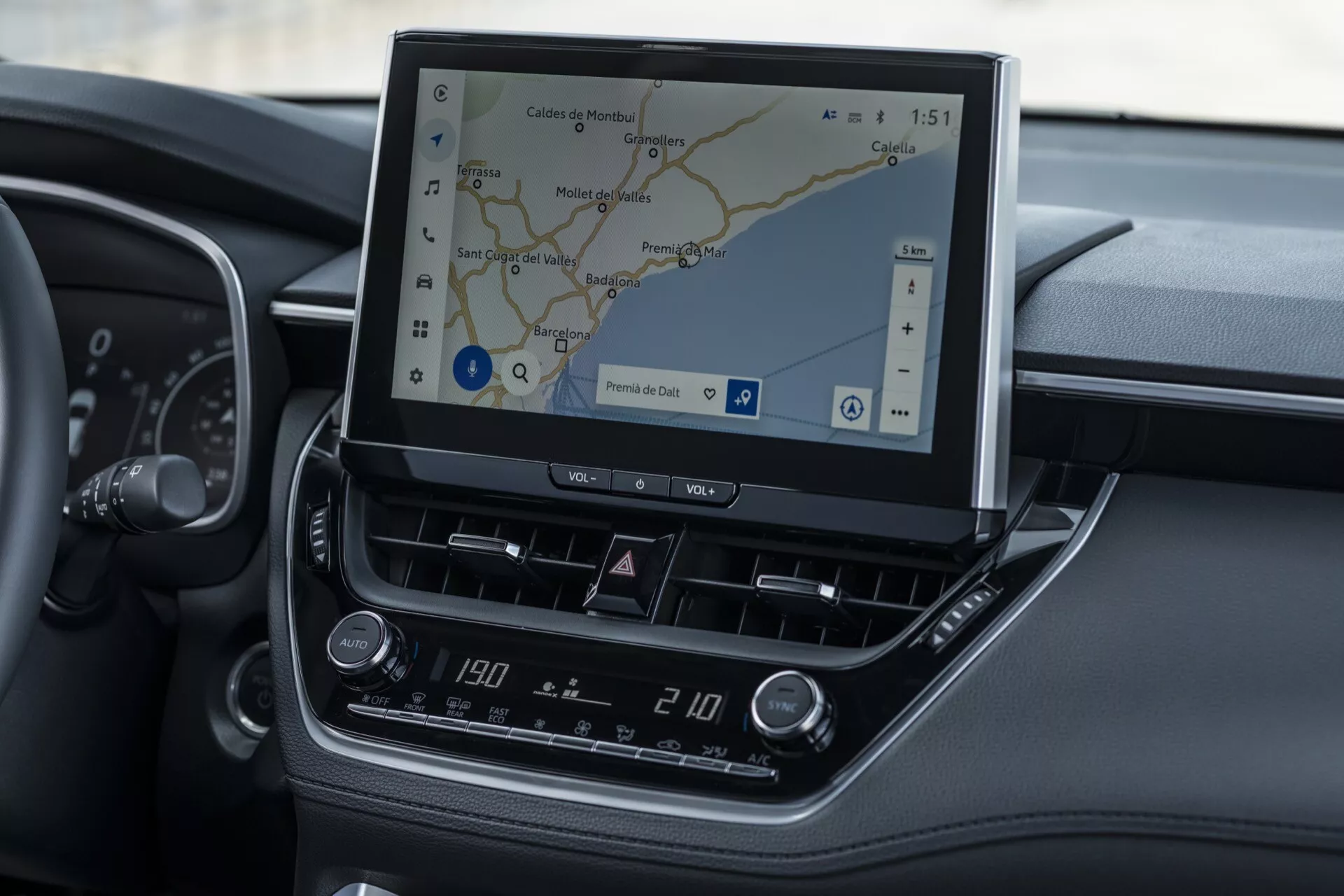 Wnętrze Toyota Corolla Cross 2022 skupiające się na systemie informacyjno-rozrywkowym i konsoli środkowej z widoczną nawigacją GPS i kontrolą klimatu