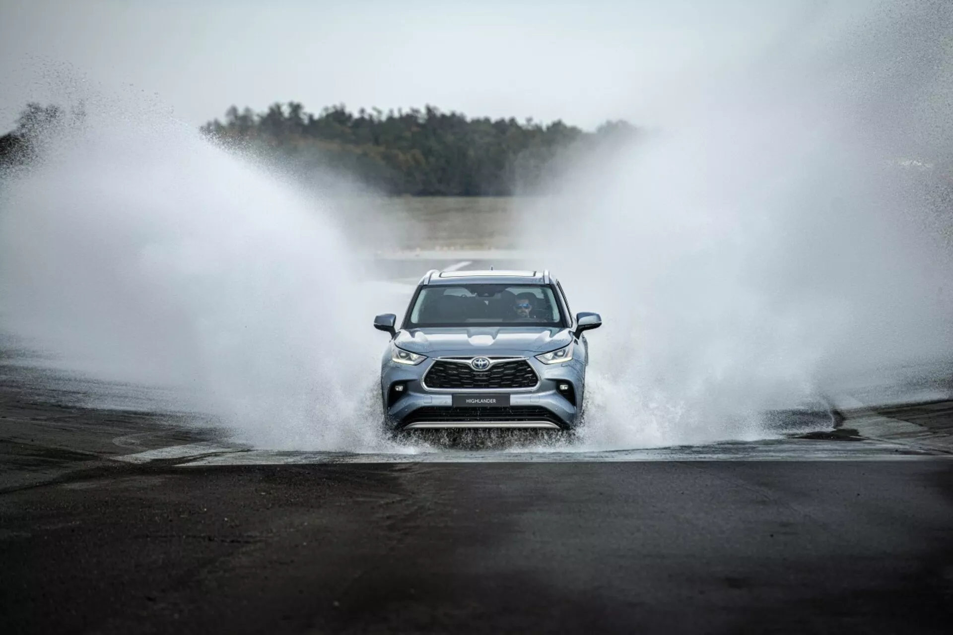 Toyota Highlander 2021 jadąca na wprost przez wodę, prezentująca przedni grill, reflektory LED i sportowy design w przygodowym otoczeniu