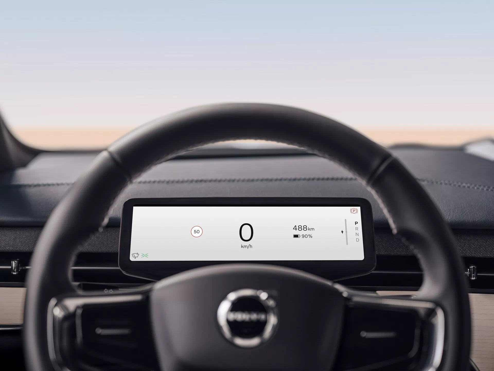 Wnętrze Volvo EX90 2023 ze skoncentrowaniem na skórzaną kierownicę i cyfrowy deska rozdzielcza wyświetlająca prędkość i zasięg baterii