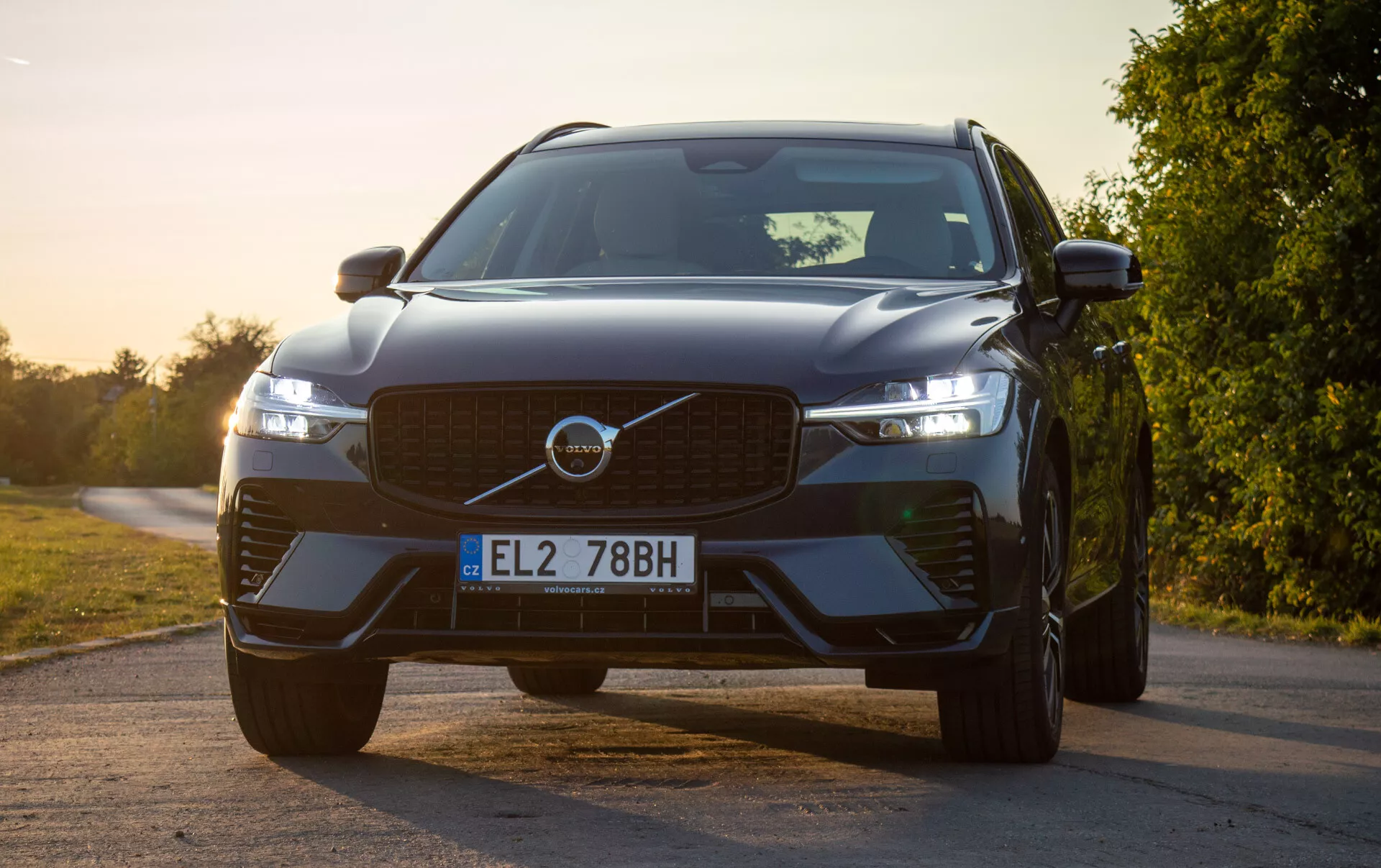 SUV Volvo XC60 Recharge plug-in hybrid z 2021 roku, widok z przodu pod kątem podkreślający grill, LED-owe reflektory z designem Młota Thora i zaawansowane czujniki bezpieczeństwa