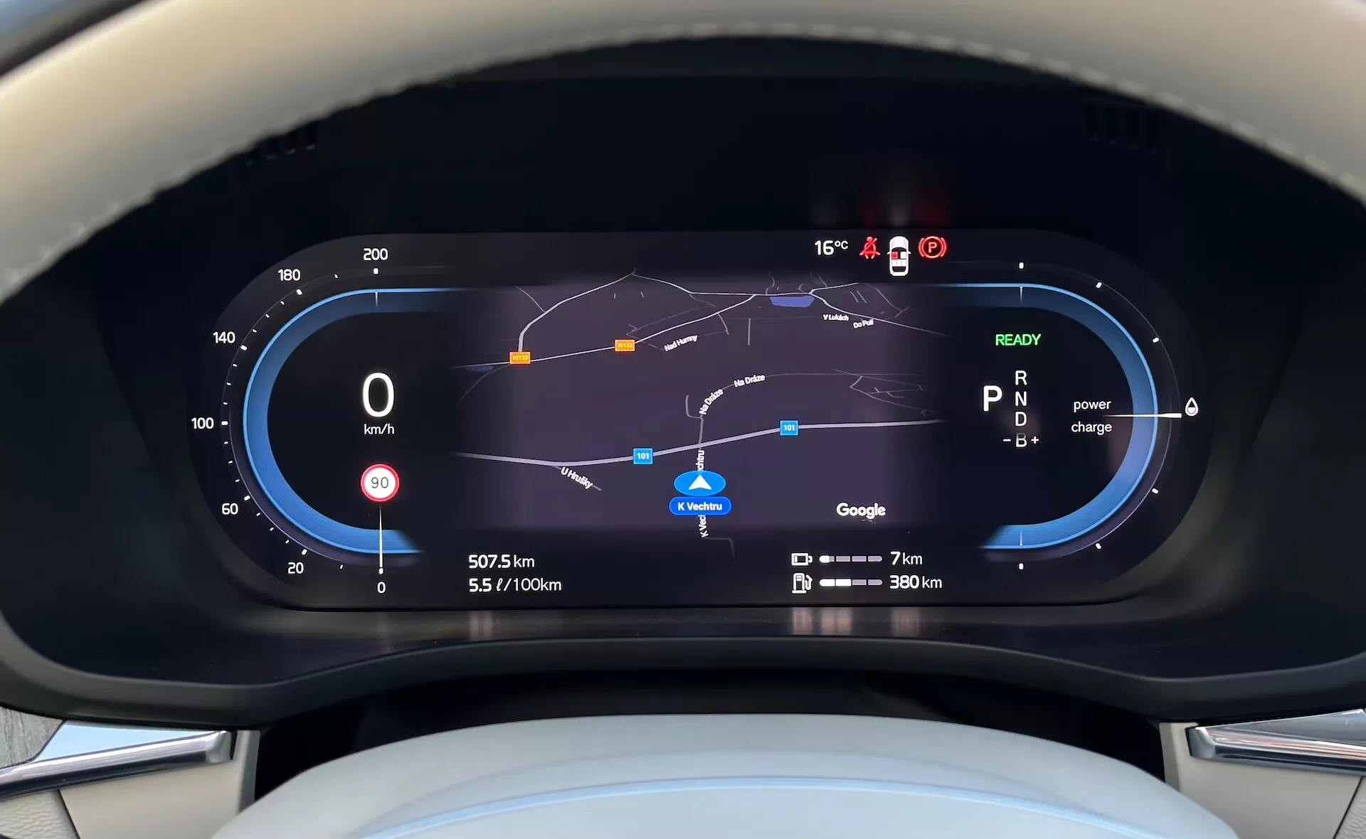 Widok na cyfrowy panel wskaźników Volvo XC60 Recharge Plug-In Hybrid 2021 z perspektywy kierowcy, zawierający prędkościomierz, wskaźnik efektywności paliwowej, użytkowanie mocy, mapę nawigacji i różne wskaźniki jazdy