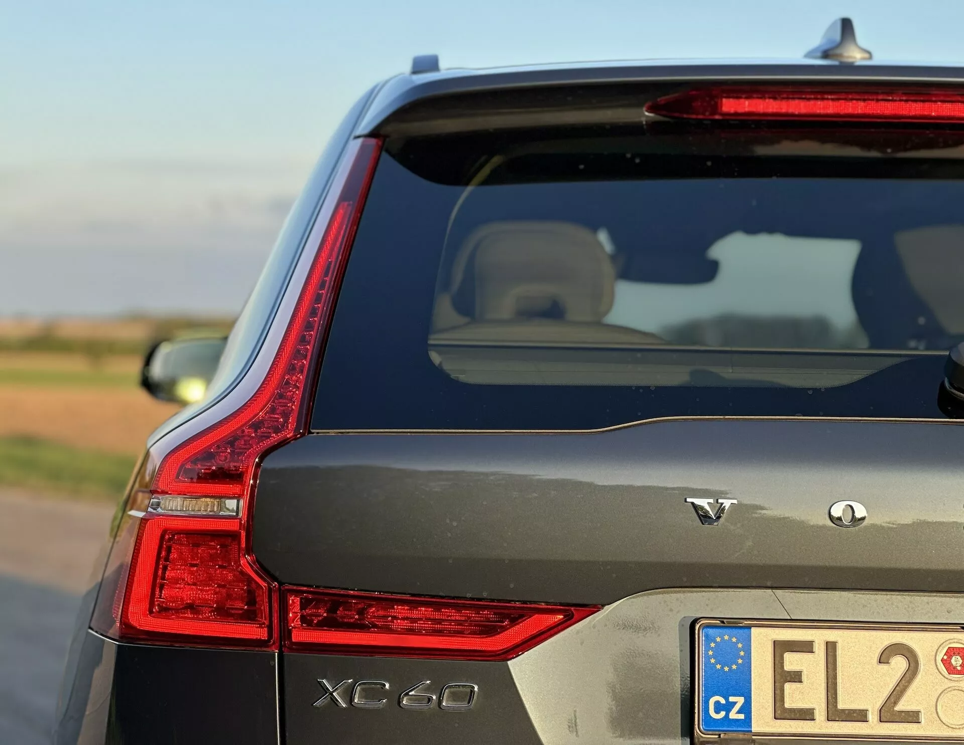 Volvo XC60 Recharge plug-in hybrydowe 2021 prezentujące elegancko zaprojektowane tylne światło LED, oznaczenia AWD i charakterystyczne cechy zewnętrzne w naturalnym świetle dziennym