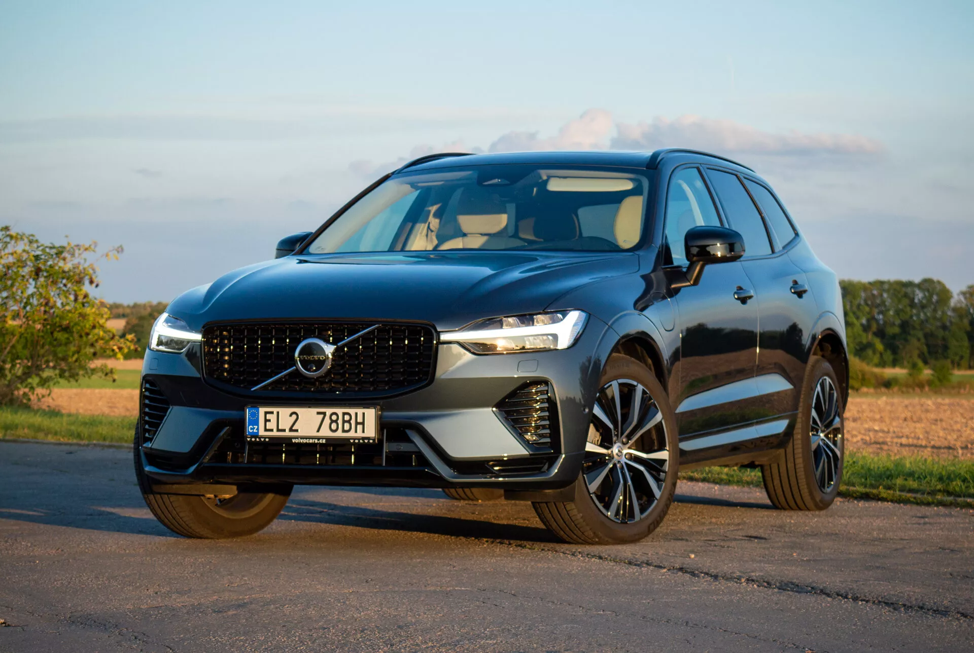 SUV Volvo XC60 Recharge Plug-In Hybrid 2021 zaparkowany na asfalcie, prezentujący swój elegancki design i zaawansowane funkcje technologiczne z niskiego przedniego kąta ukośnego