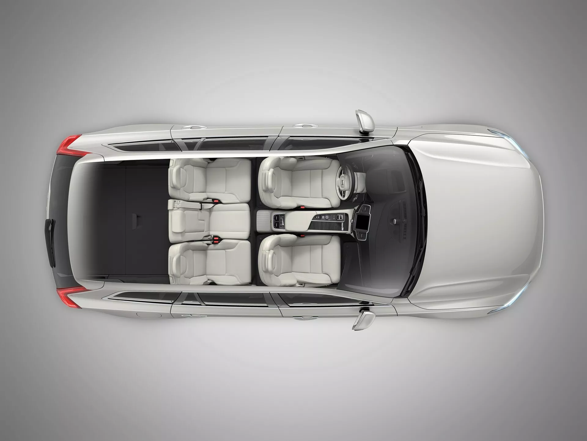 Widok z lotu ptaka na Volvo XC90 2015 (2. generacja) prezentujący luksusowy sedan z góry. Kąt zapewnia wyraźny widok na dach, maskę, bagażnik i powierzchnie drzwi. Cechy obejmują dwupanelowy szyberdach nad przednimi siedzeniami, jasne wnętrze o układzie siedzeń dla pięciu pasażerów, aluminiowe felgi i widoczne lusterka boczne. Tylna szyba jest stromo nachylona, a żadne konkretne identyfikatory marki nie są widoczne.