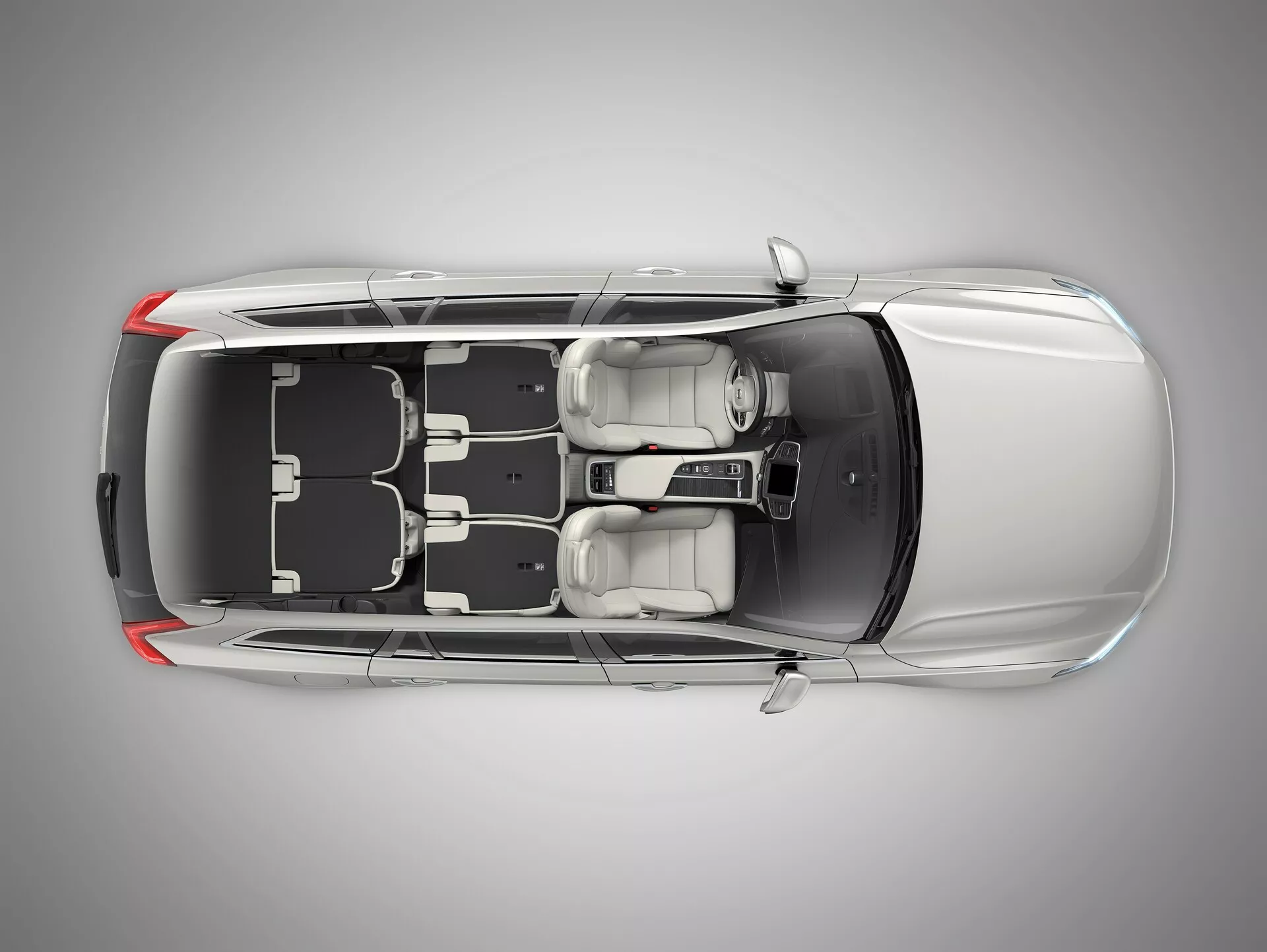 Widok z lotu ptaka na Volvo XC90 drugiej generacji z 2015 roku, ukazujący czarny dach i metalicznie srebrne lub szare nadwozie z szyberdachem, zamkniętymi drzwiami i oknami. Wyraźnie widoczne są koła i wzór felg, a także boczne lusterka, co podkreśla bezpieczeństwo i cechy zewnętrzne. Zwężająca się linia dachu z tyłu sugeruje, że może to być czterodrzwiowy sedan lub coupe.