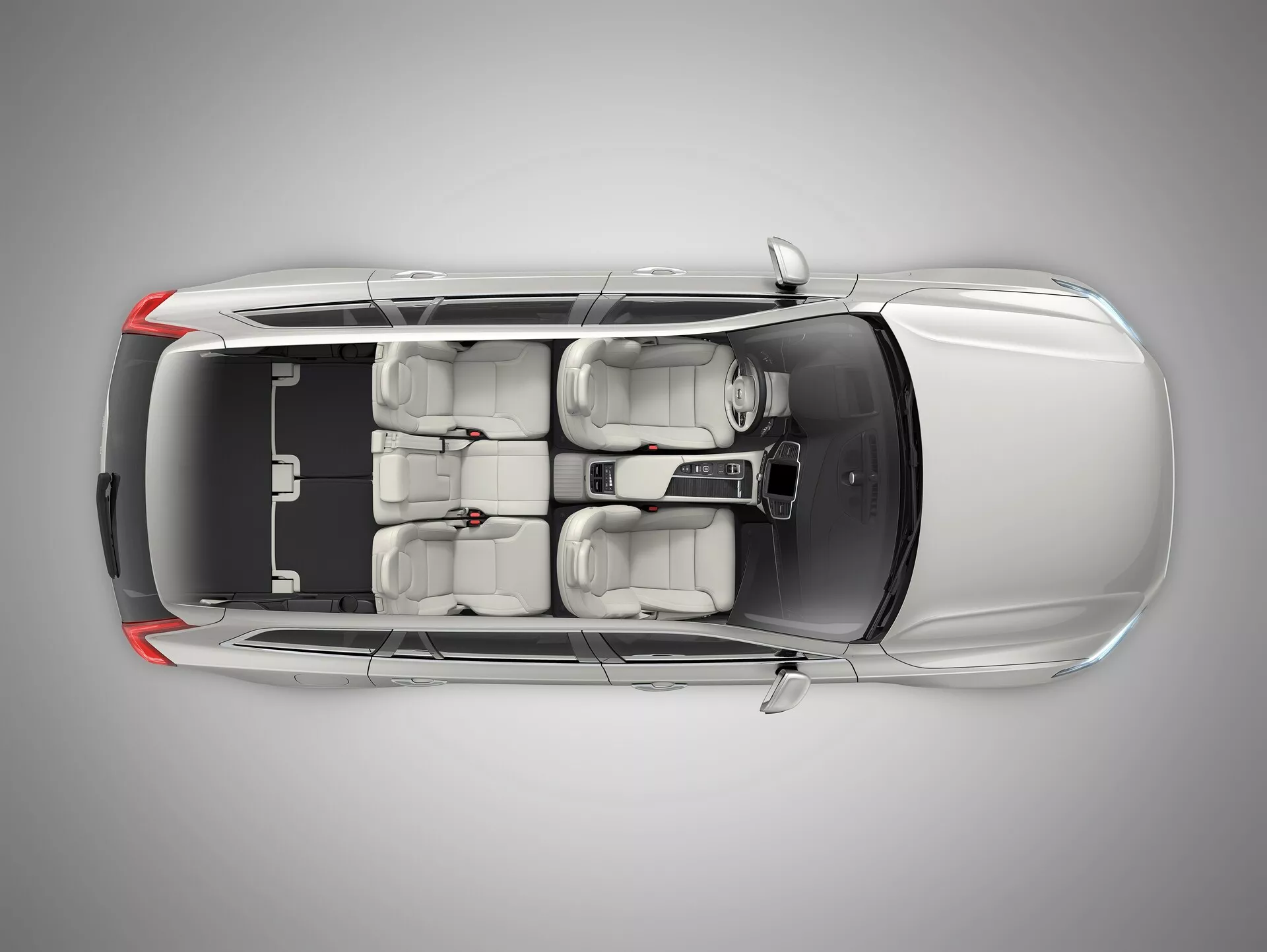 Widok z góry metalicznego Volvo XC90 2015 z kontrastującym czarnym dachem, aerodynamicznym designem, szyberdachem, dwoma rzędami siedzeń z zaawansowanymi regulowanymi przednimi fotelami, centralną konsolą sterowania i przyciemnianymi szybami, ułożony w profesjonalnym studiu.