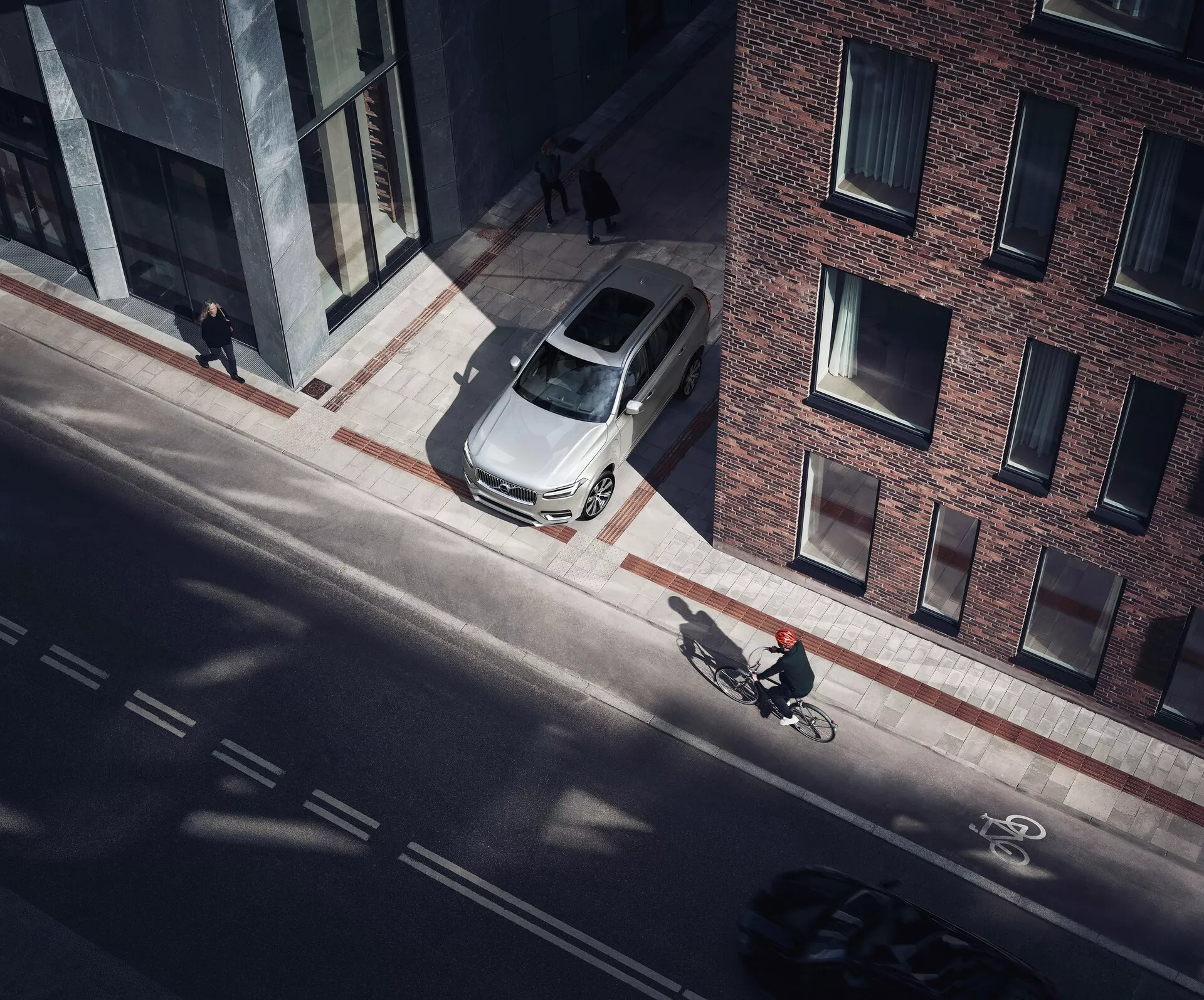 Widok z boku Volvo XC90 2015, prezentujący elegancki i nowoczesny design. Druga generacja tego luksusowego SUV-a wyróżnia się elegancką metaliczną karoserią, charakterystycznym przednim grillem, reflektorami LED i aluminiowymi felgami.