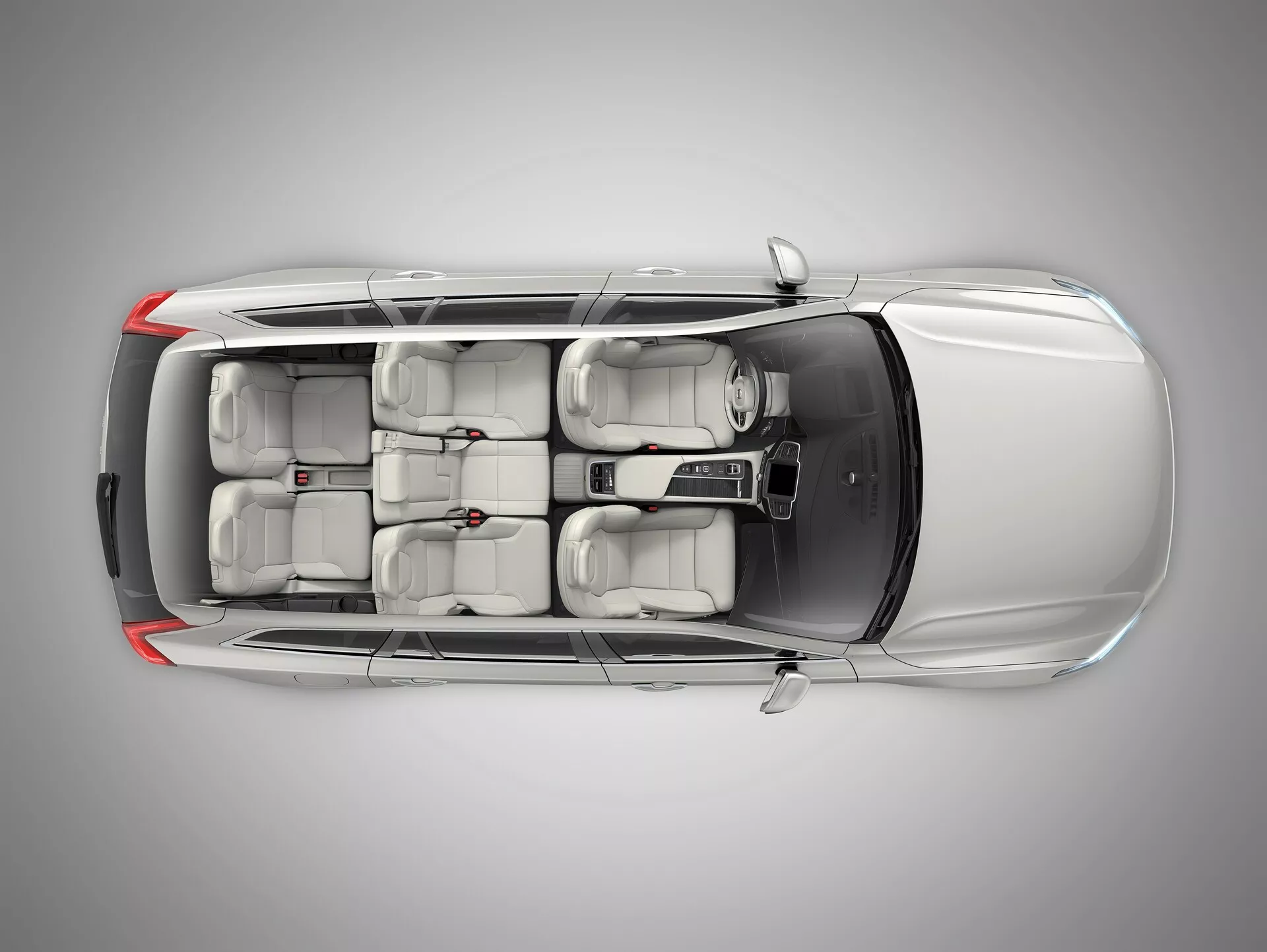 Widok z góry Volvo XC90 2015 (2. generacja), pokazujący dach z panelem panoramicznego lub sunroof, cztery drzwi z klamkami wpuszczanymi w karoserię oraz trzema rzędami siedzeń dla siedmiu pasażerów, co wskazuje na nowoczesny design i konfigurację z kierownicą po lewej stronie.