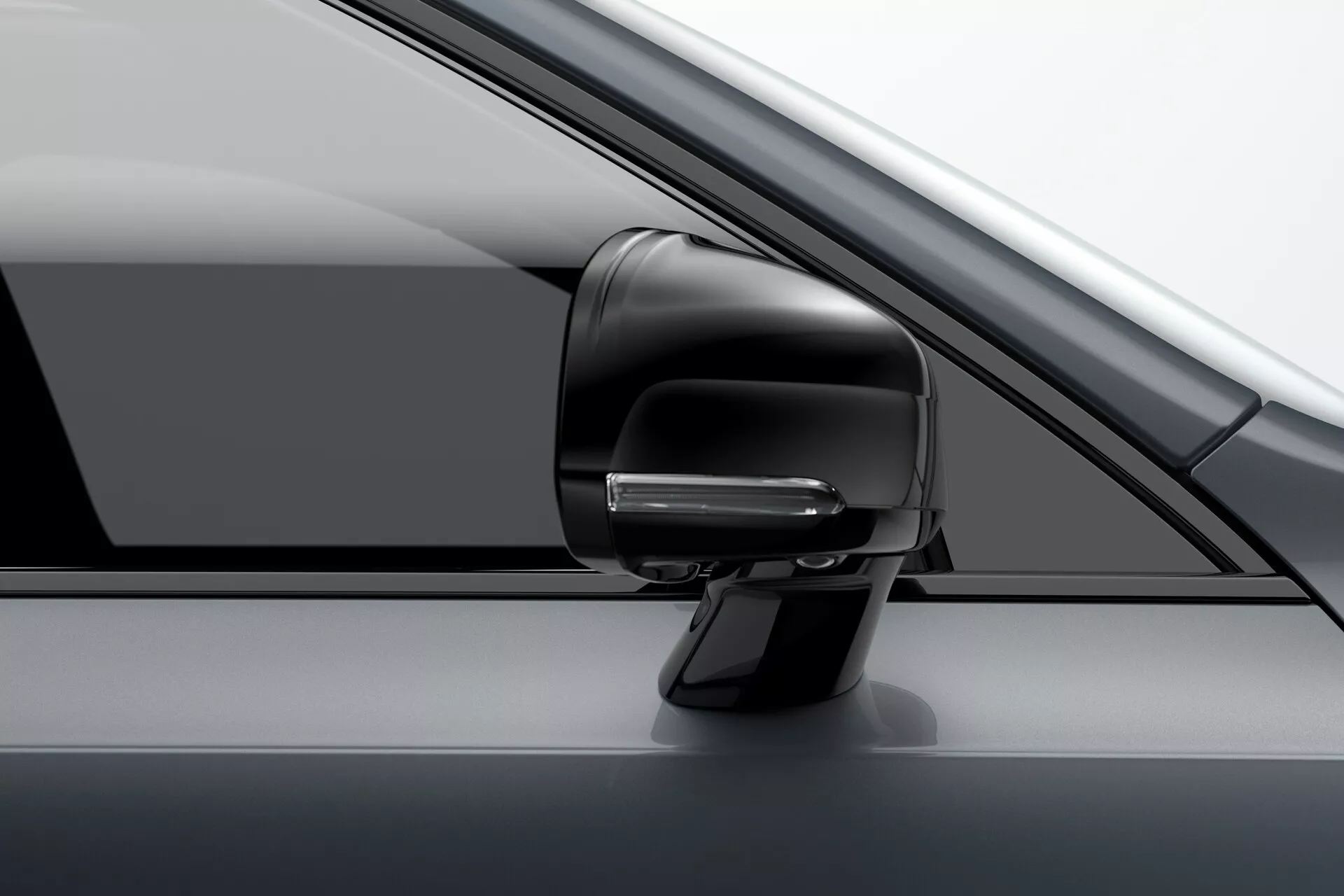 Zbliżenie zespołu lusterka bocznego po stronie kierowcy Volvo XC90 z 2015 roku (2. generacja). Obraz podkreśla nowoczesny, aerodynamiczny design z wbudowanym kierunkowskazem, prawdopodobnie będącym częścią zaawansowanego systemu wspomagania kierowcy, oraz obudową w tym samym kolorze. Widoczny jest częściowy widok słupka A, bocznej szyby i panelu drzwi. Zdjęcie wykonano pod nieznacznie przednim kątem, ukazując luksusowy, monochromatyczny wygląd pojazdu.
