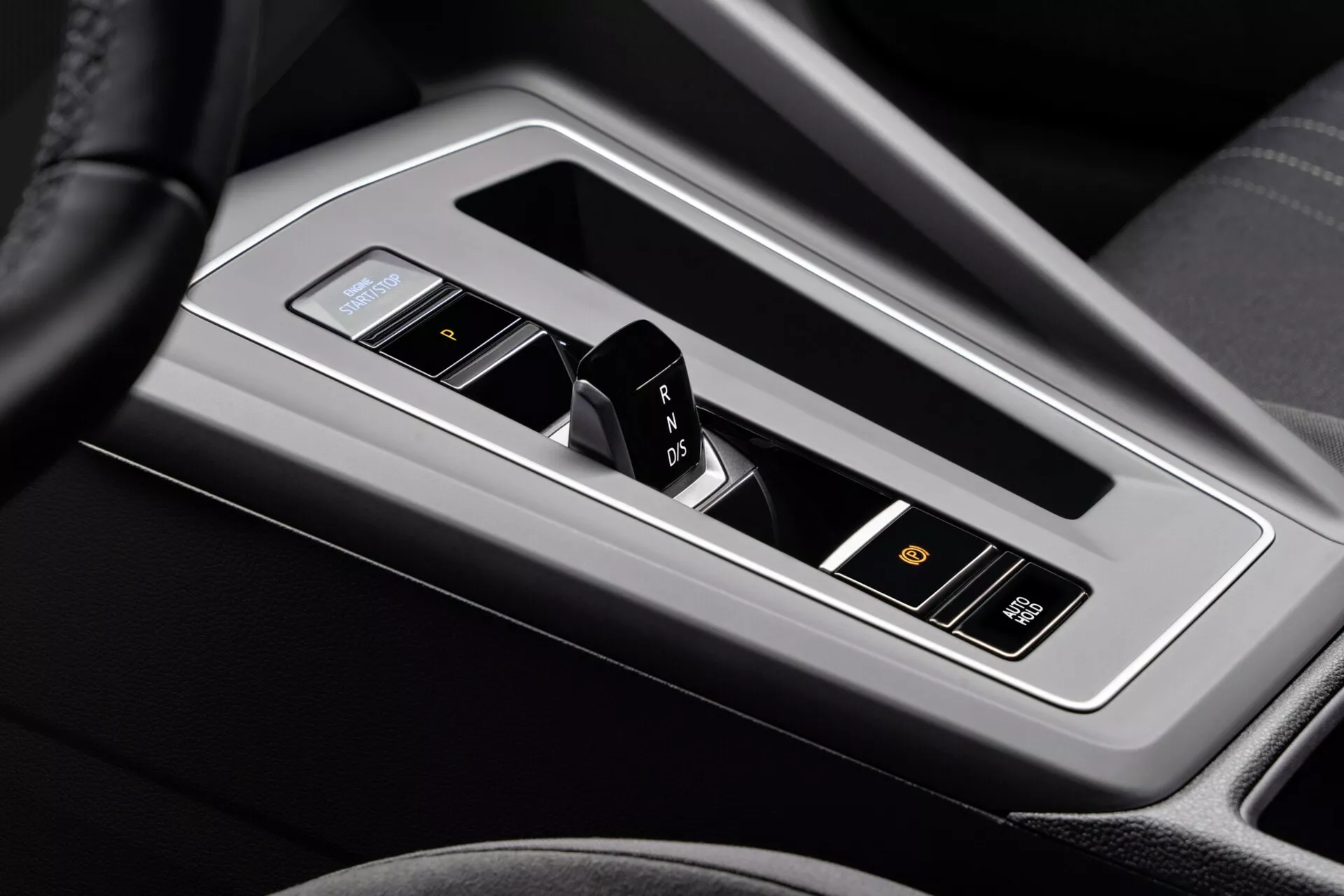 Zbliżenie na konsolę środkową VW Golf Alltrack 2017 z elektronicznym selektorem biegów w automatycznej skrzyni biegów z układem P R N D, przyciskiem start/stop bez kluczyka i luksusowymi detalami wnętrza