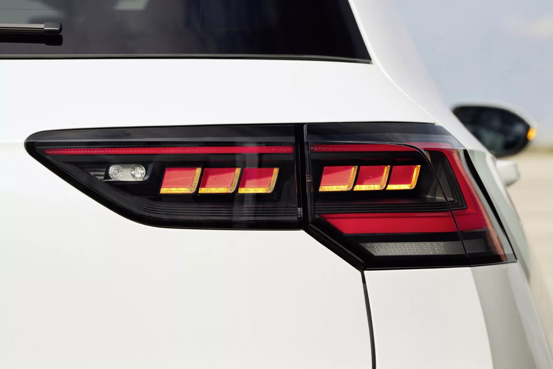 Zbliżenie na tylny narożnik VW Golfa 2024 (VIII-Facelift) prezentujący projekt tylnych świateł LED, podkreślający nowoczesną i luksusową estetykę pojazdu