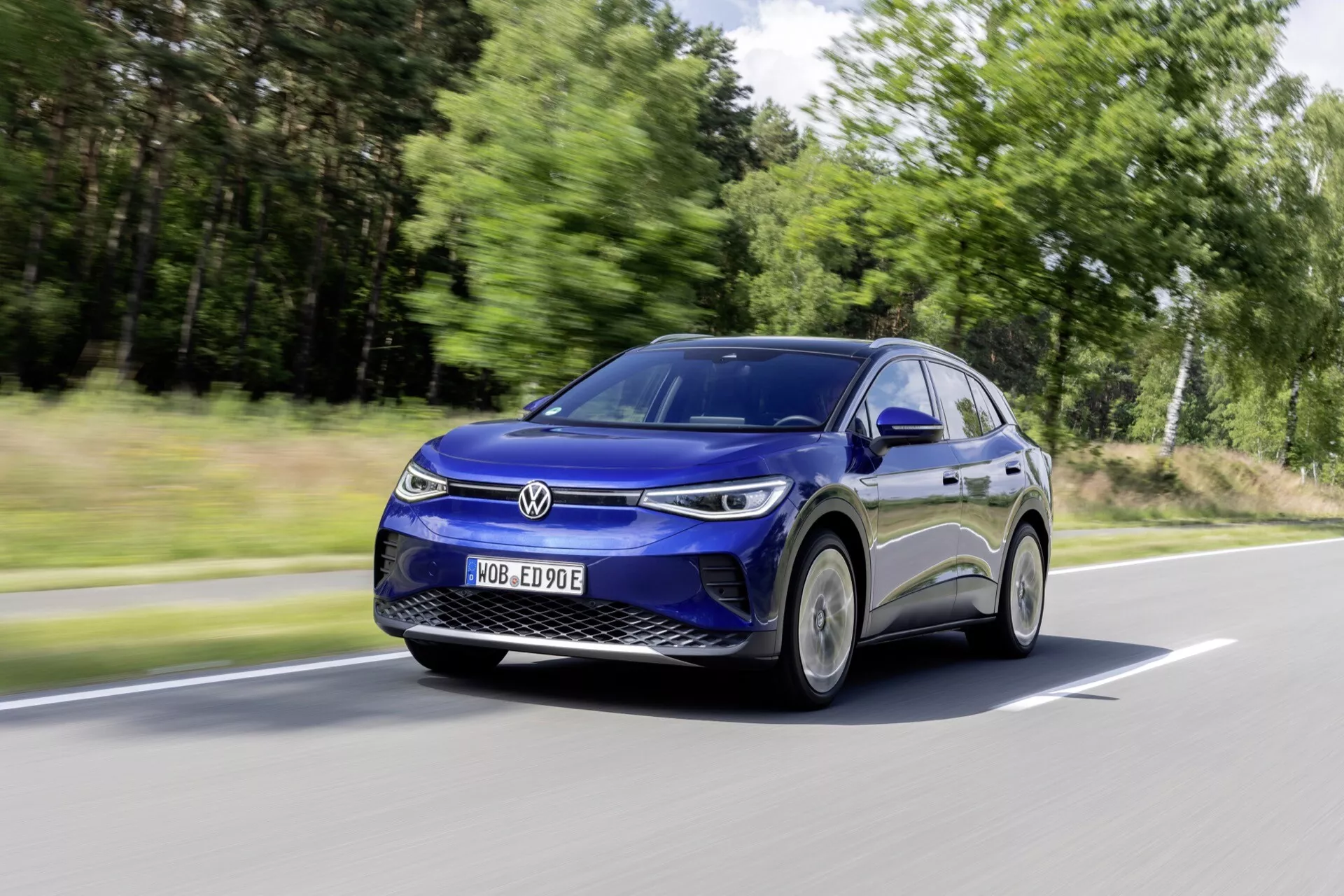 Dynamiczny widok kątowy poruszającego się Volkswagena ID.4, podkreślający jego elektryczny design SUV, elegancką aerodynamikę i nowoczesne reflektory LED