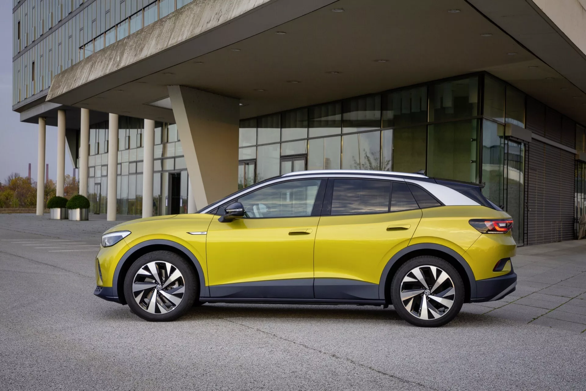Profil VW ID.4 1. generacji z 2020 roku prezentujący elegancki design, aerodynamiczny profil oraz nowoczesne funkcje jak oświetlenie LED i panoramiczny dach przeciwsłoneczny na tle miejskim