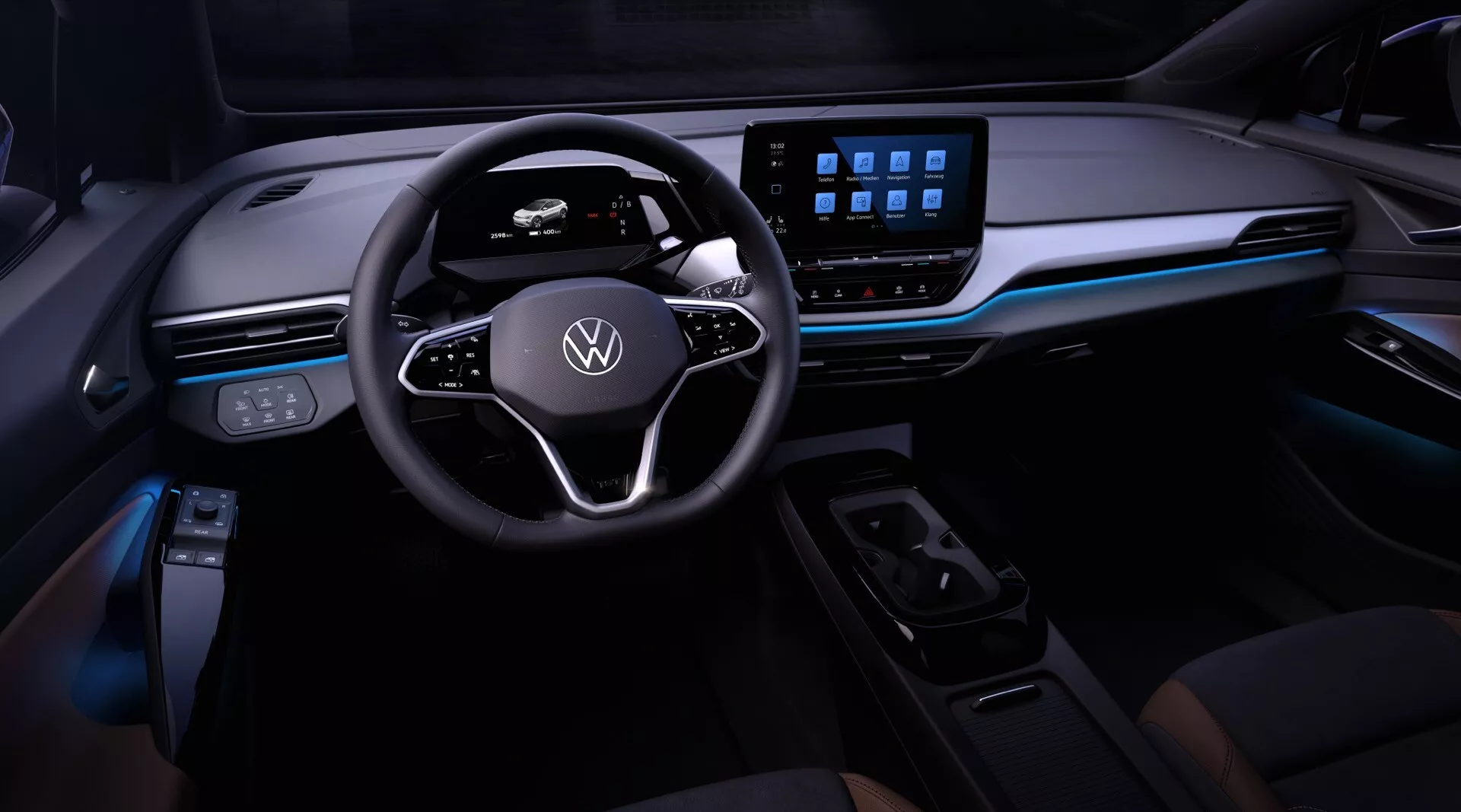 Widok wnętrza Volkswagen ID.4 2020 z perspektywy kierowcy, skupiający się na desce rozdzielczej, kierownicy z logo Volkswagen i przyciskami wielofunkcyjnymi, cyfrowym zespole wskaźników, dużym systemie infotainment z ekranem dotykowym, eleganckiej desce rozdzielczej z oświetleniem ambientowym, minimalistycznej kontroli klimatu i selektorze zmiany biegów sterowanym elektronicznie.