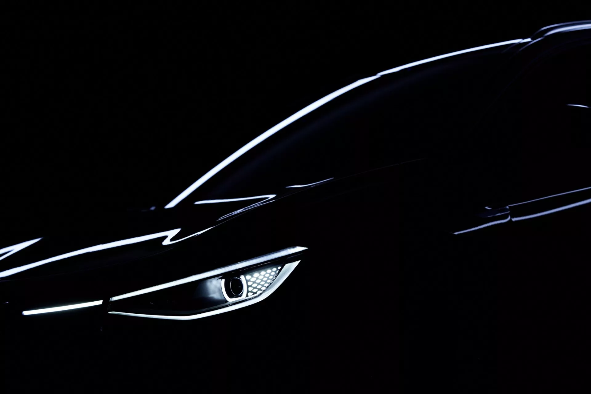 Zbliżenie na VW ID.4 2020 (1. generacja) podkreślające kątowy reflektor LED, gładką aerodynamiczną karoserię i subtelnie odbijającą światło metaliczną farbę na ciemnym tle - skupienie się na nowoczesnych detalach designu samochodowego i technologii.
