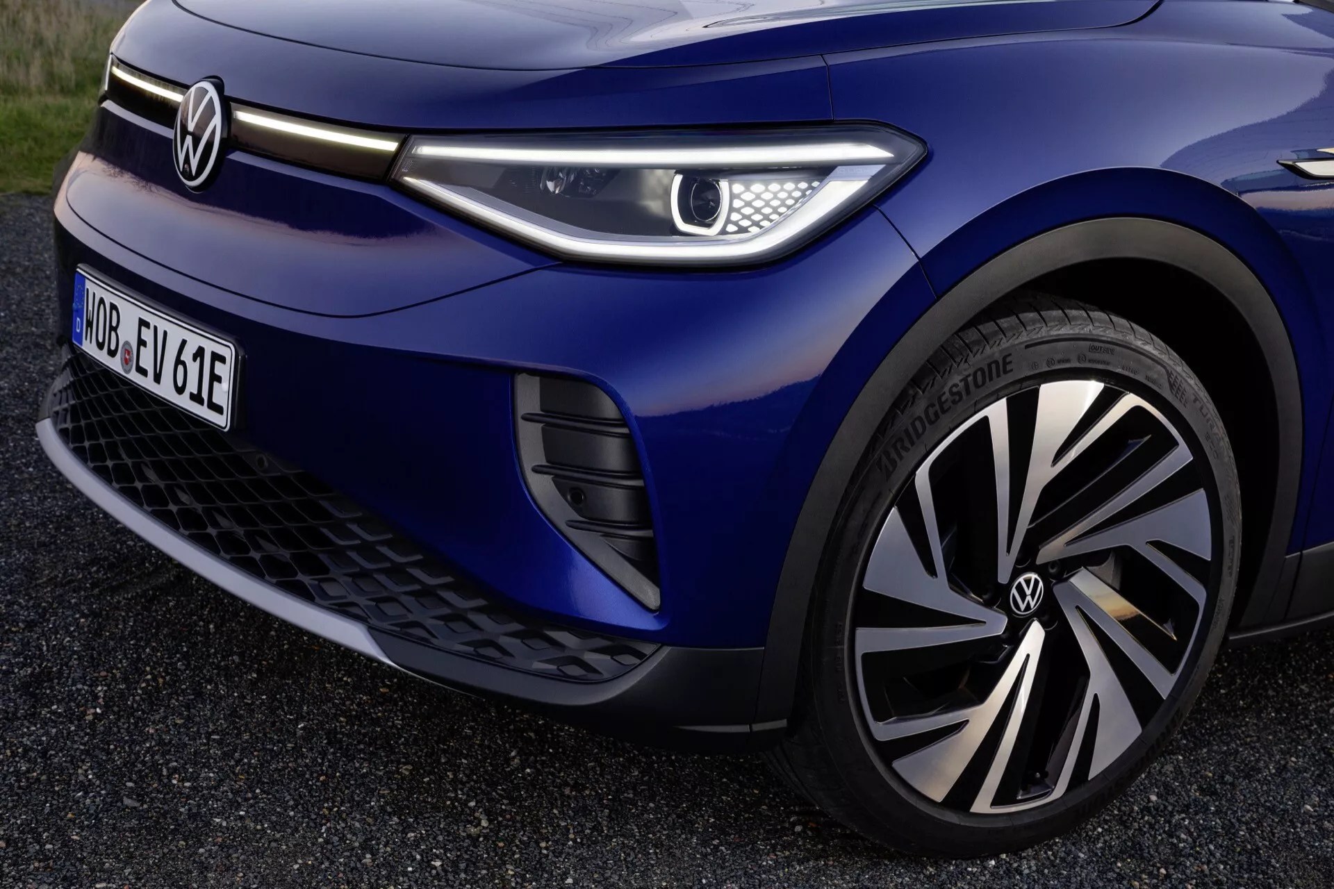 Widok kwartału przedniego Volkswagen ID.4 z 2020 roku z detalami takimi jak koło markowe, reflektor LED, aerodynamiczny grill i metaliczny niebieski lakier, podkreślające zaawansowaną technologię oświetlenia, design pojazdów elektrycznych, technologię kół i funkcje wspomagające kierowcę.