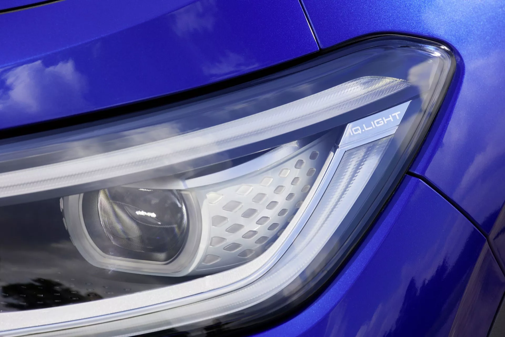 Zbliżenie na reflektor VW ID.4 2020 1. generacji z technologią LED i napisem Q LIGHT na niebieskiej karoserii
