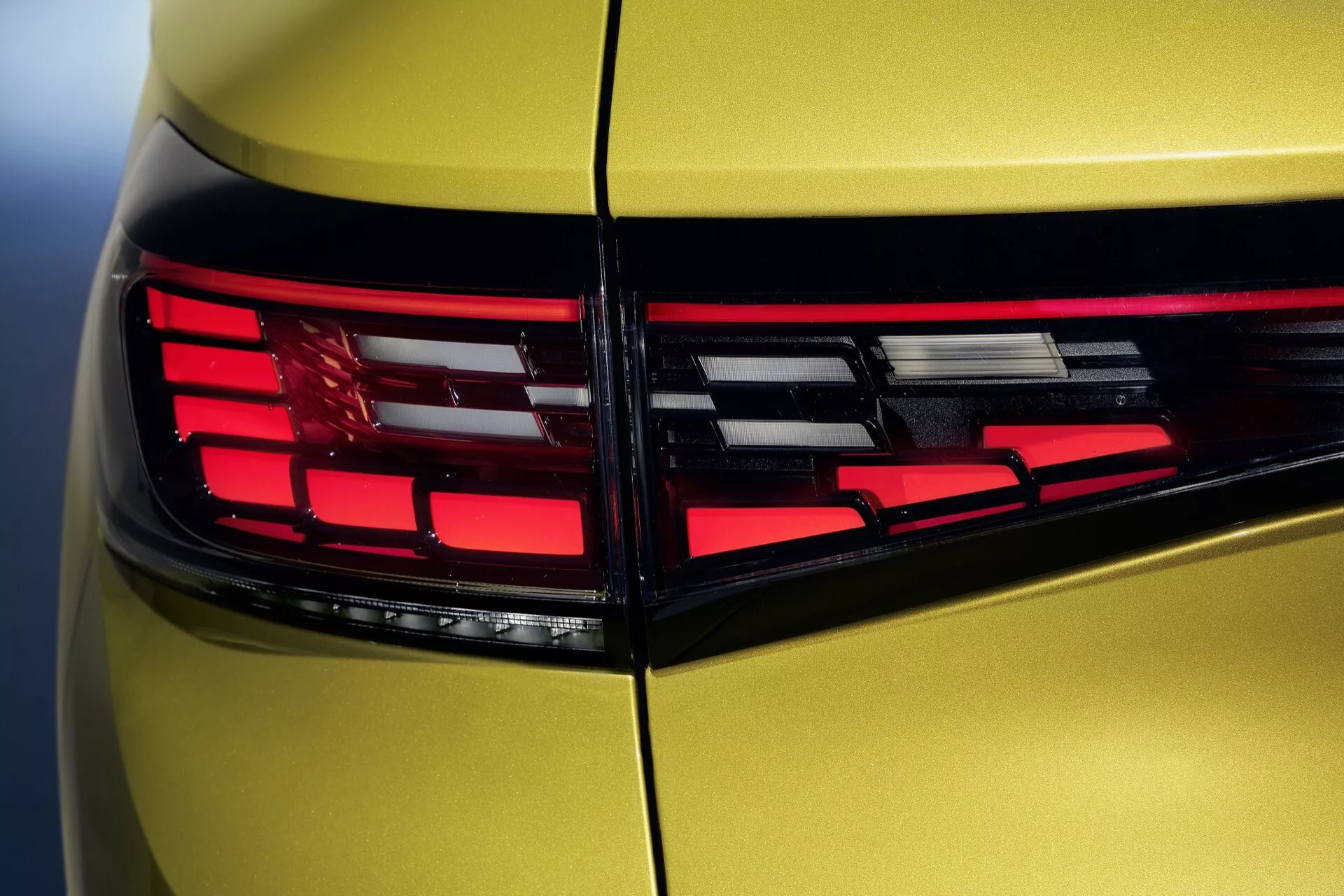 Zbliżenie na tylną ćwiartkę VW ID4 2020 z LEDowym światłem tylnym i metalicznym lakierem z perspektywy trzech czwartych tyłu, podkreślające nowoczesną technologię oświetlenia i aerodynamiczny design