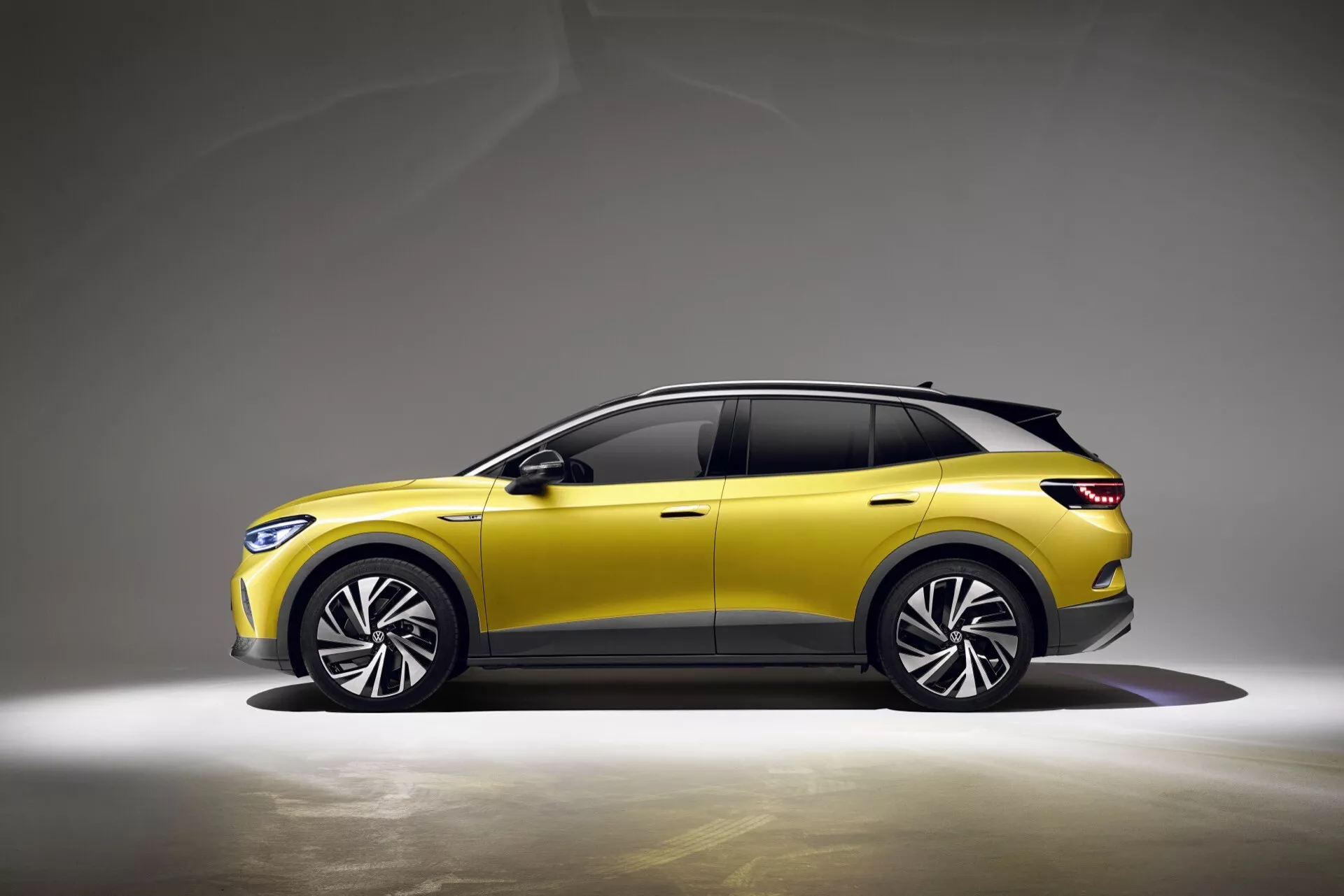 VW ID.4 1. generacji 2020 w żywej żółci z eleganckim profilem, zaawansowanymi reflektorami LED, dynamicznymi kołami ze stopów i potencjalną technologią wspomagającą kierowcę, na neutralnym tle podkreślającym crossover/SUV design i nowoczesną estetykę.