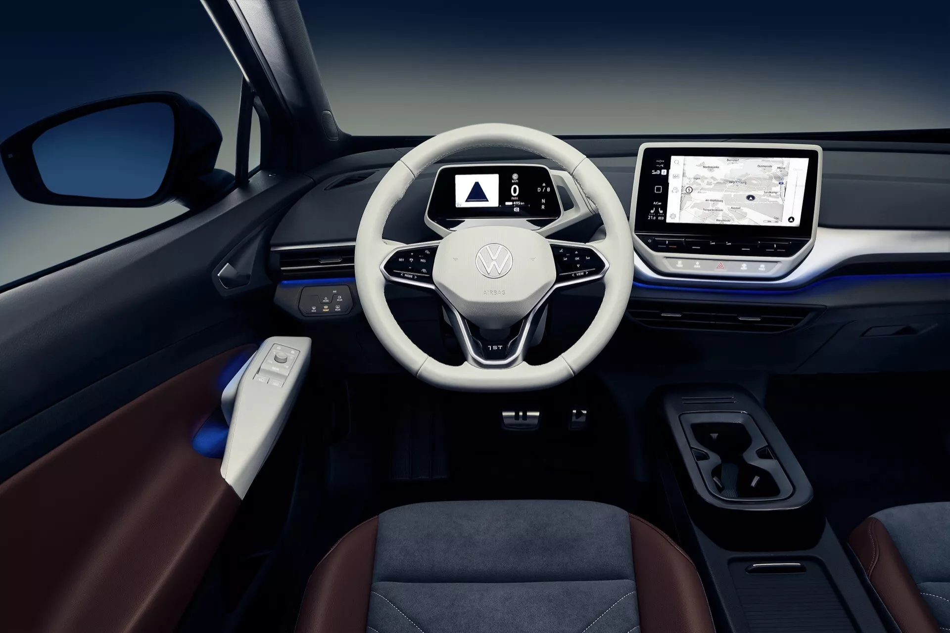 Widok wnętrza VW ID.4 1. generacji z 2020 roku, skupiający się na desce rozdzielczej, kierownicy z logo Volkswagen, cyfrowym panelu wskaźników i systemie infotainment z ekranem dotykowym i nawigacją, obok minimalnej konsoli centralnej i paneli drzwi z oświetleniem ambientalnym wskazujących na jakość premium i nowoczesność