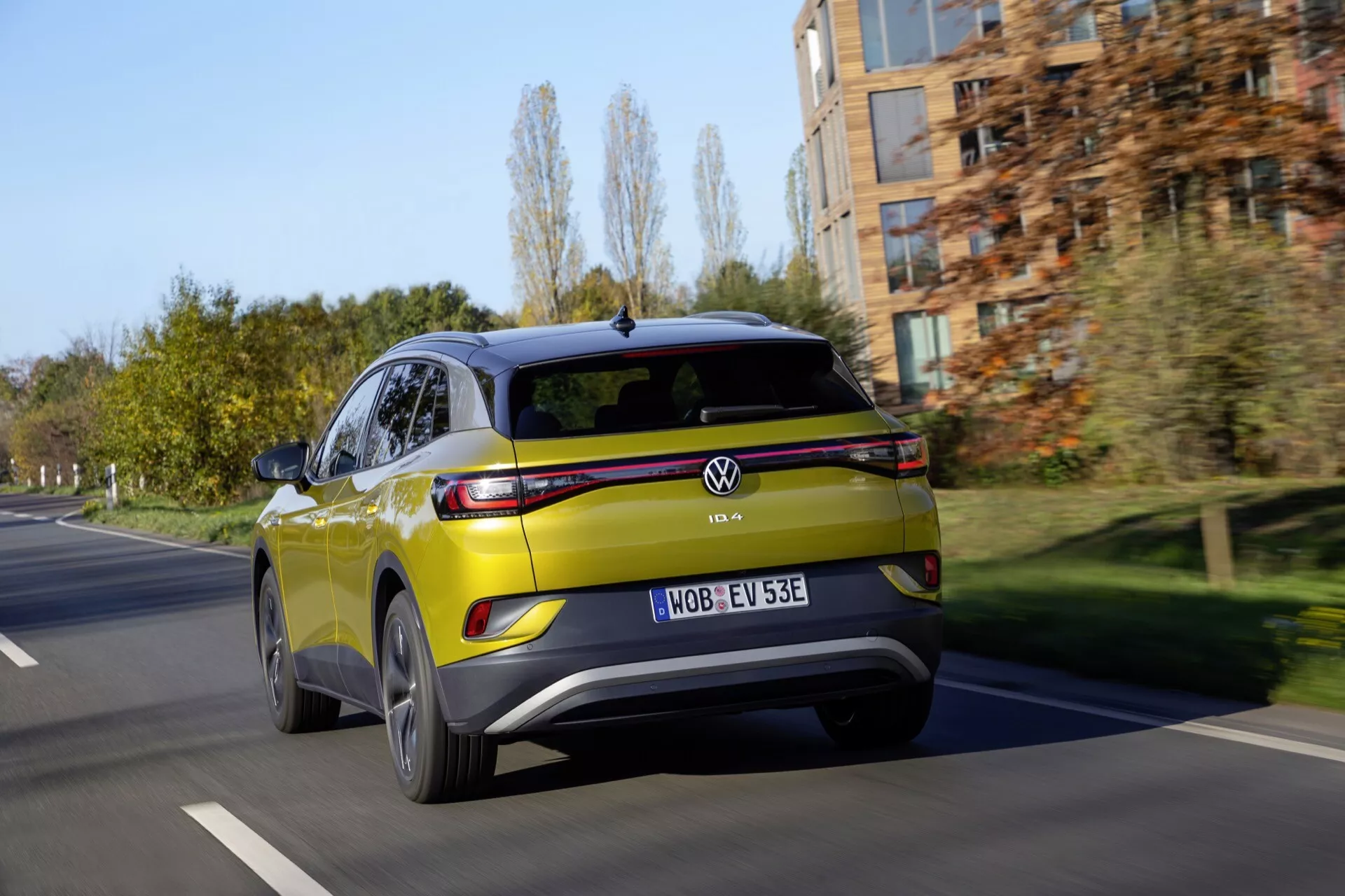 VW ID4 1. generacji z 2020 roku w ruchu, prezentujący aerodynamiczną sylwetkę, tylne światła LED i ekologiczne cechy projektu na miejskiej drodze.