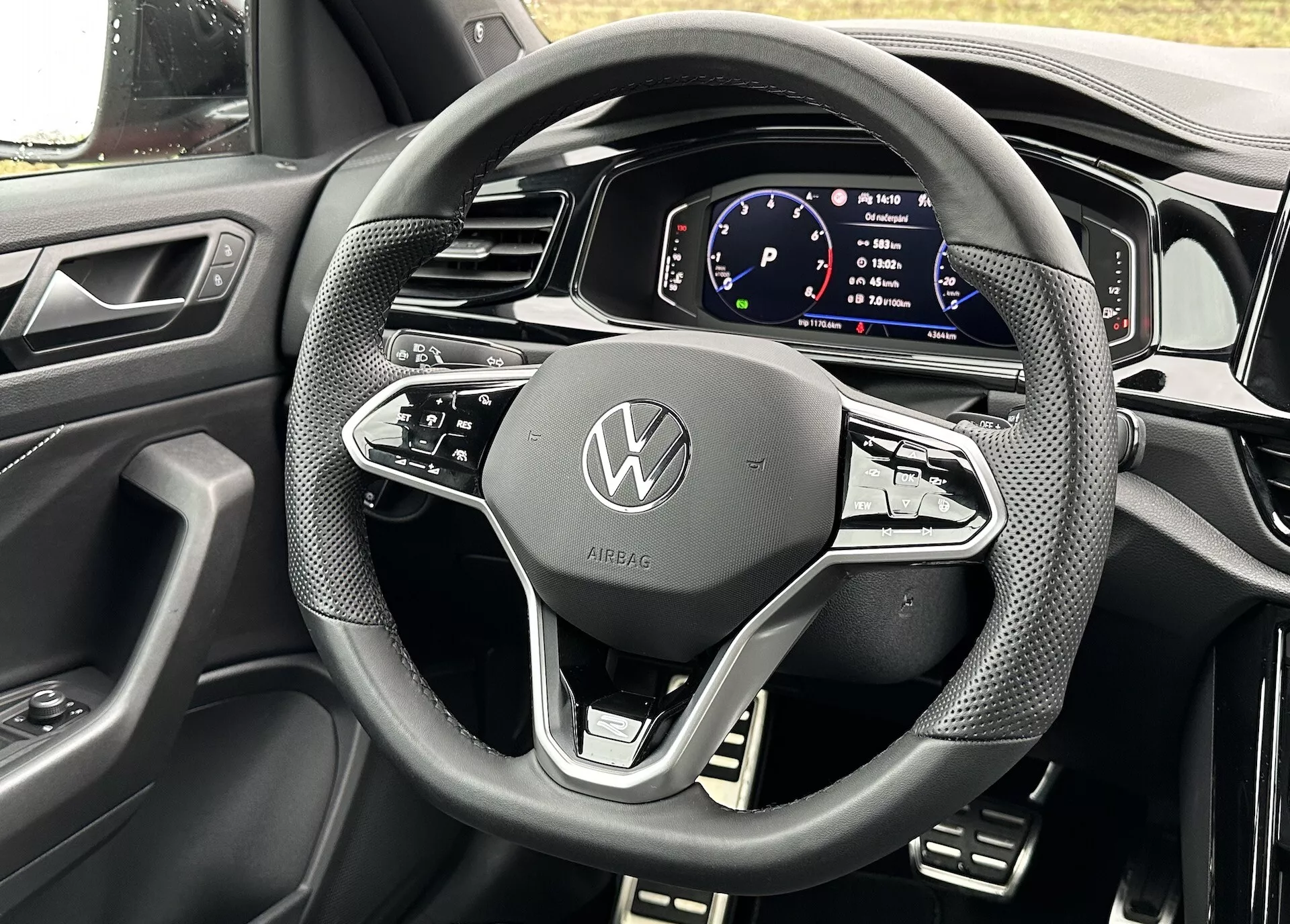 Szczegółowy widok z perspektywy kierowcy na kierownicę i cyfrowy panel instrumentów kabrioletu Volkswagen T-Roc 2022, prezentujący nowoczesny design i funkcje technologiczne