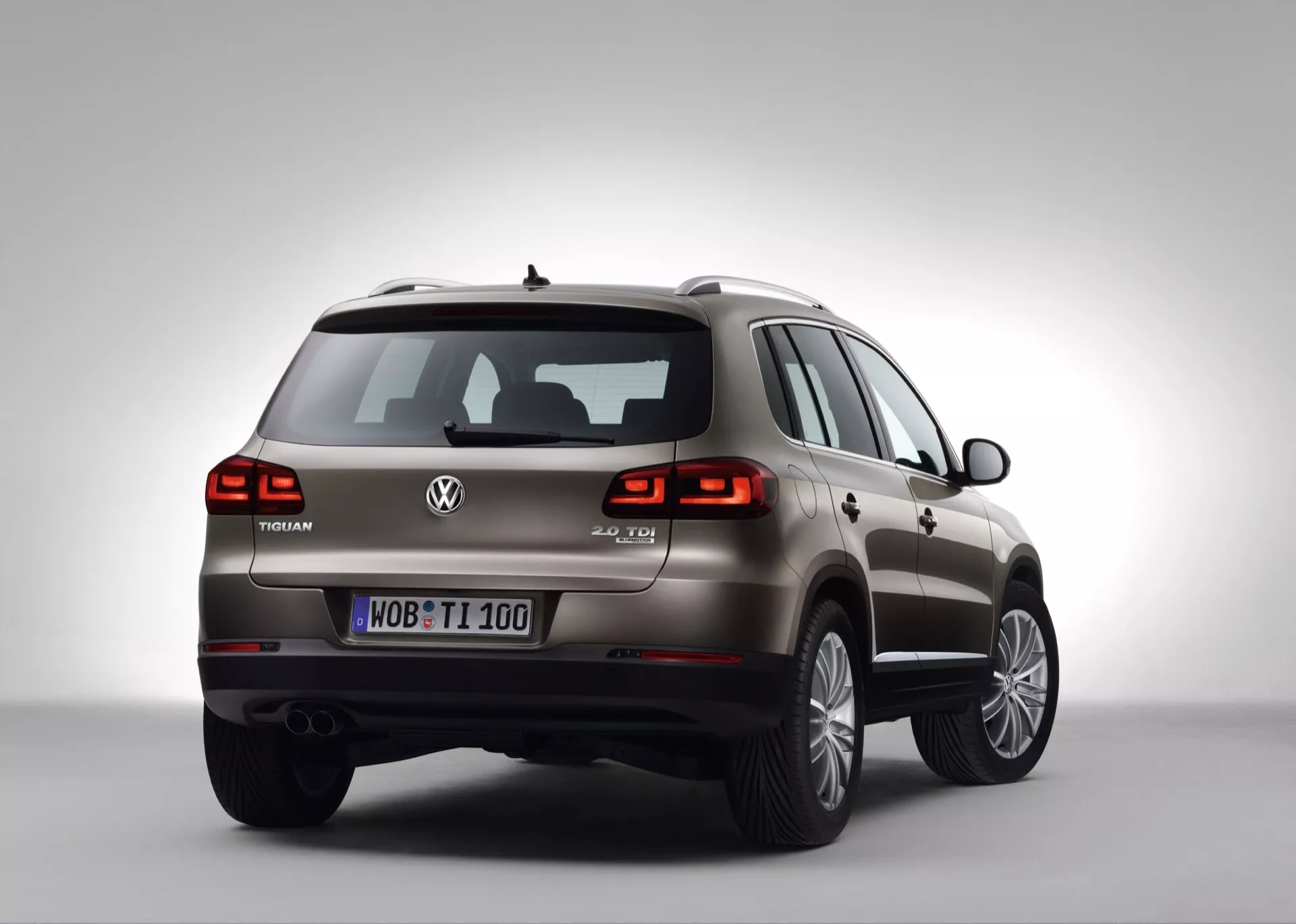 SUV Volkswagen Touareg w studio, trzy czwarte z tyłu pokazujące prawą stronę, tył, tylne światła LED, oznaczenie V6 TDI i wieloramienne felgi aluminiowe na tle z gradientem