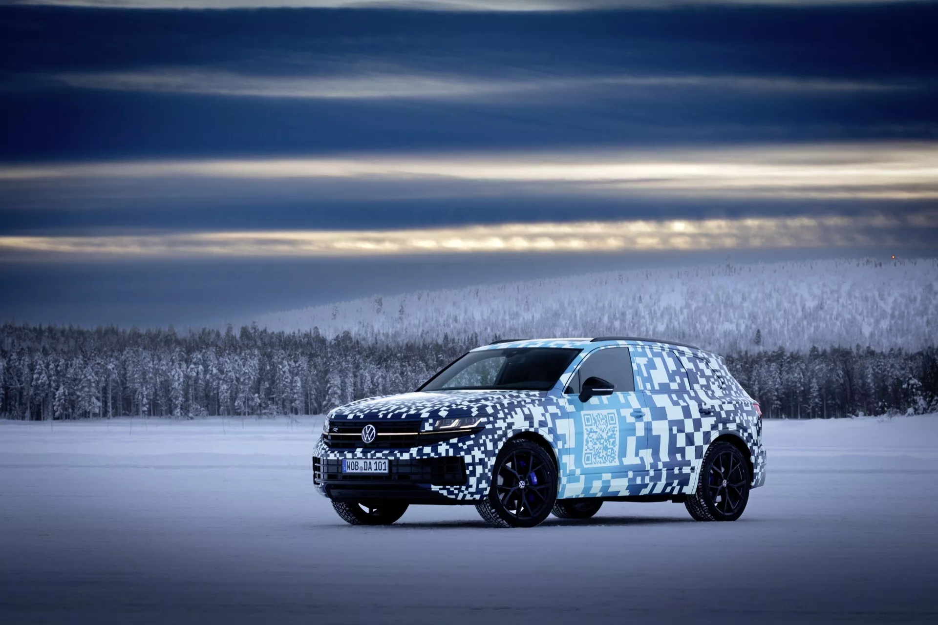 Widok z profilu bocznego Volkswagen Touareg III facelift 2023 na śnieżnym terenie z kamuflażem pokazującym długość pojazdu, aerodynamiczny design i zaawansowany system oświetleniowy