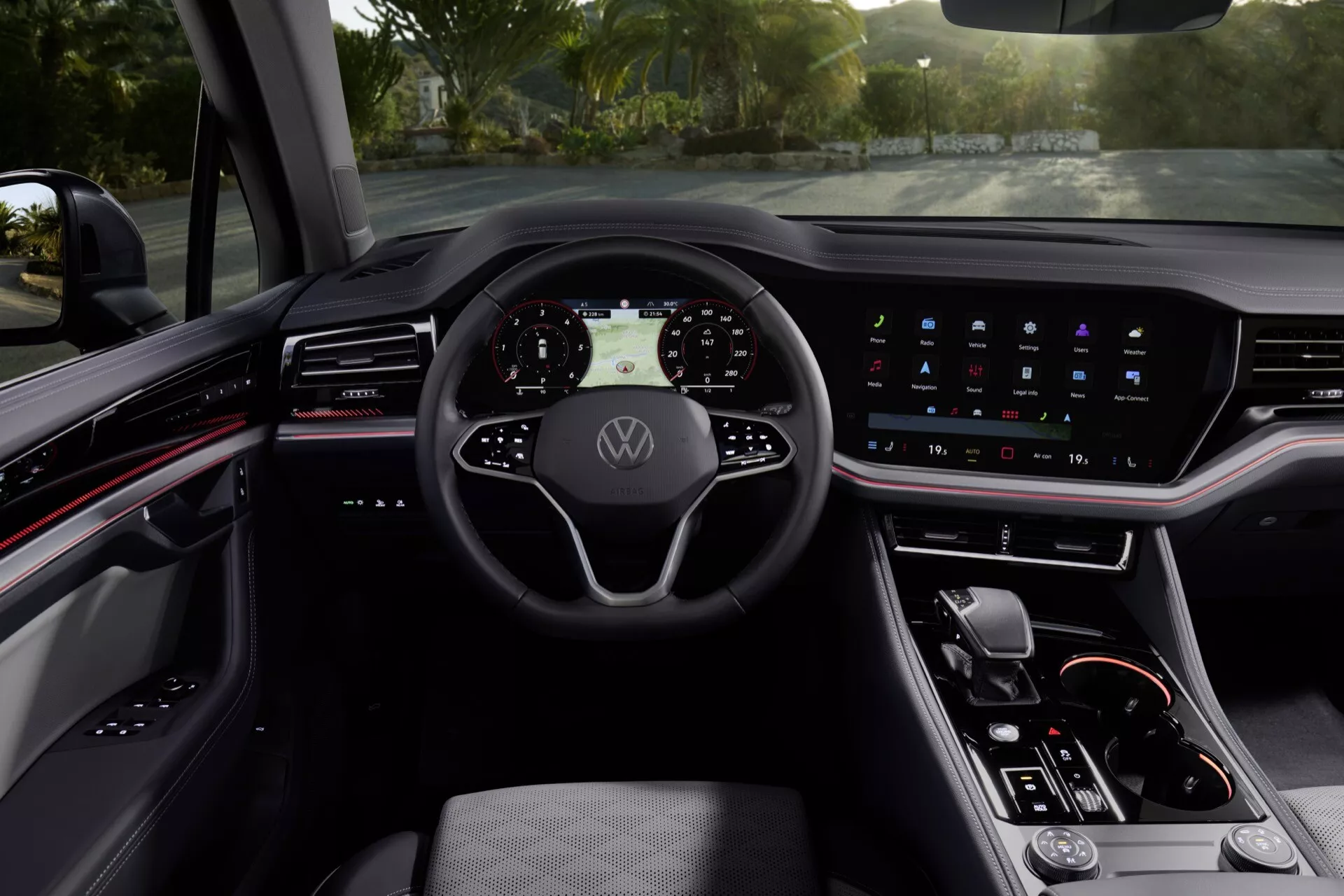 Wnętrze Volkswagen Touareg (III-Facelift) 2023 z cyfrowym kokpitem, wielofunkcyjną kierownicą z emblematem Volkswagen, zintegrowanym ekranem dotykowym systemu infotainment, minimalistycznymi kontrolkami na konsoli środkowej i wyrafinowaną ciemną kolorystyką z oświetleniem ambientowym