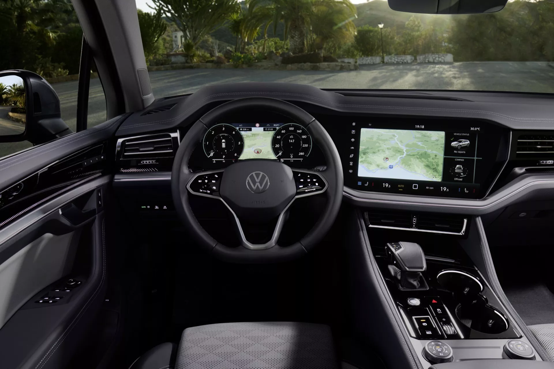Widok wnętrza VW Touareg 2023 (III-facelift) z perspektywy miejsca kierowcy przedstawiający cyfrową deskę rozdzielczą, kierownicę z przyciskami sterującymi oraz dotykowy system infotainment