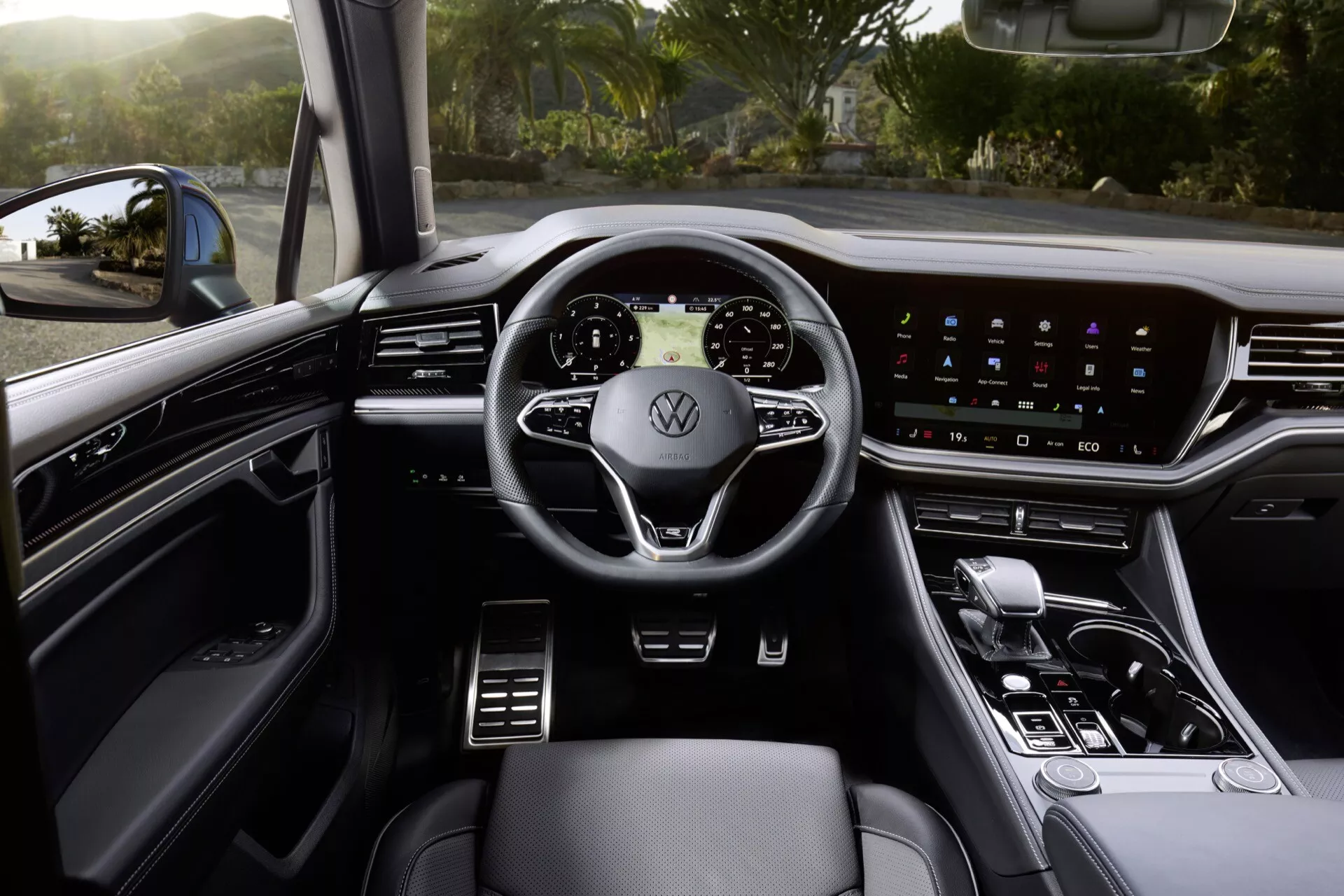 Widok wnętrza VW Touareg 2023 skupiony na perspektywie kierowcy, w tym wielofunkcyjna kierownica, szeroki ekran dotykowy na desce rozdzielczej i wykończenia z materiałów wysokiej jakości